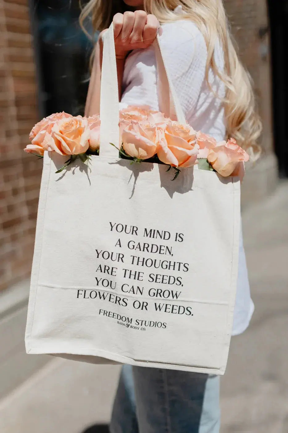 Canvas tote bag with inspirational quote 'Your mind is a garden' holding peach roses, farmhouse style decor