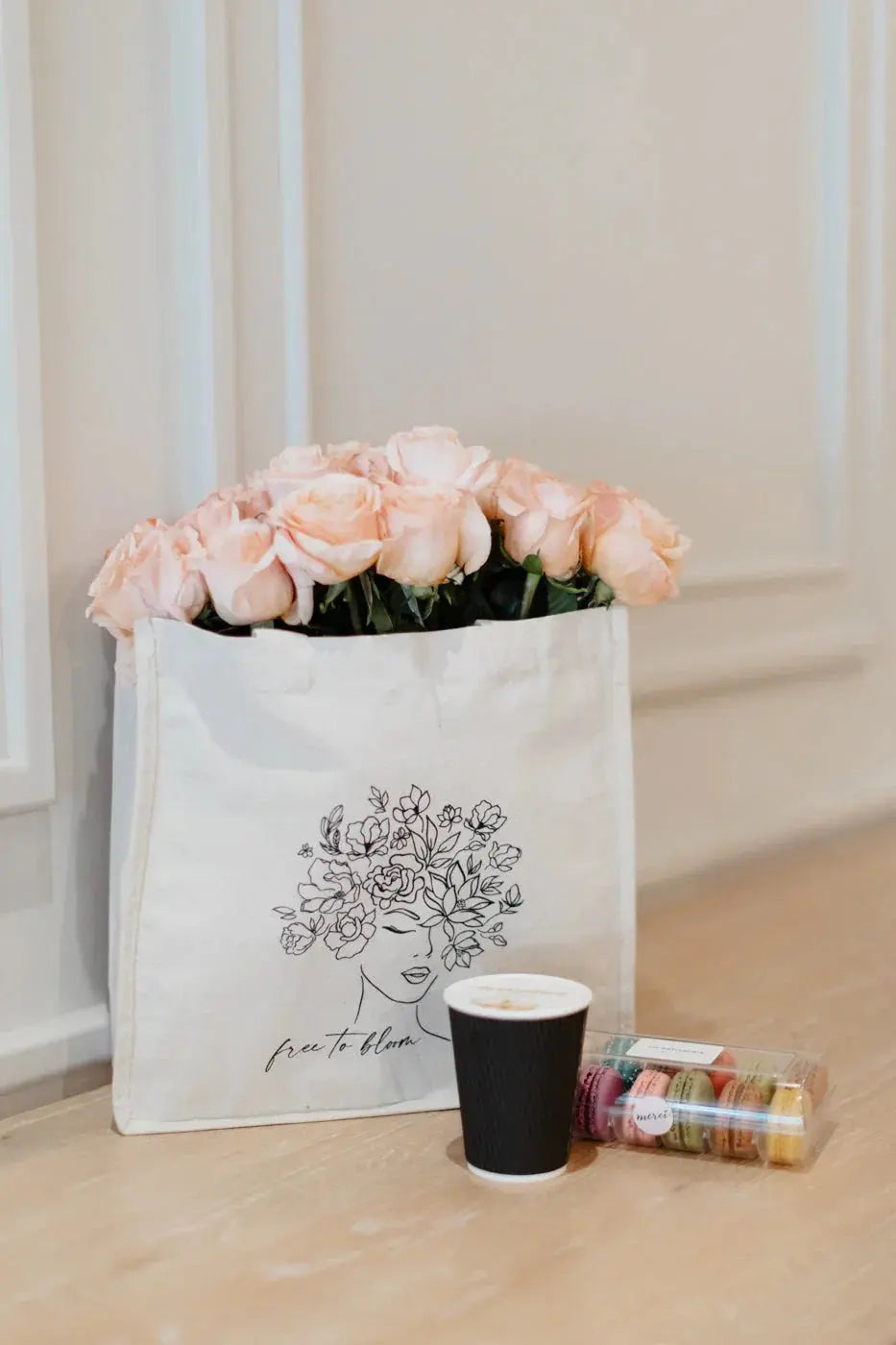 Pink roses in floral tote bag with coffee cup and macarons, cozy cottage style home decor