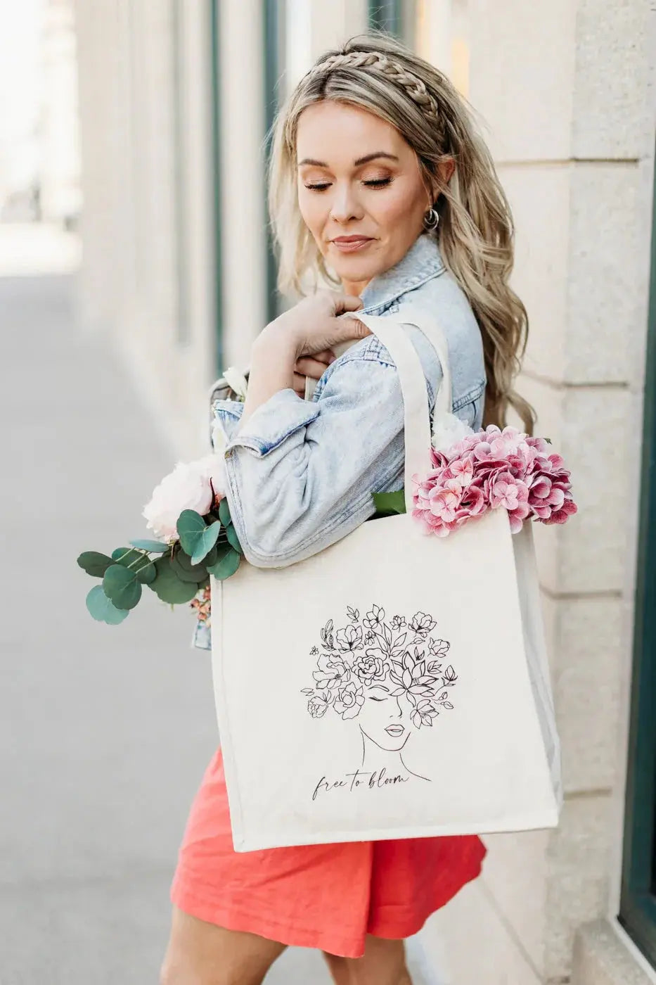 Woman holding floral tote bag with 'free to bloom' design, perfect for cozy cottage style gifts and everyday use.