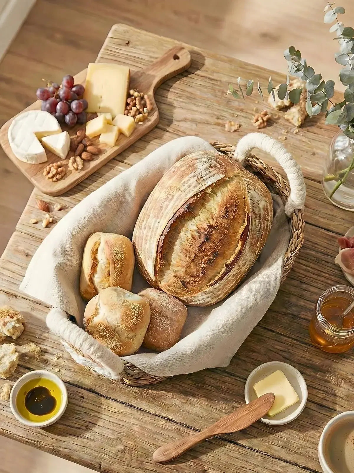 Rustic farmhouse bread basket with artisan sourdough, cheese, grapes, and honey on wooden table