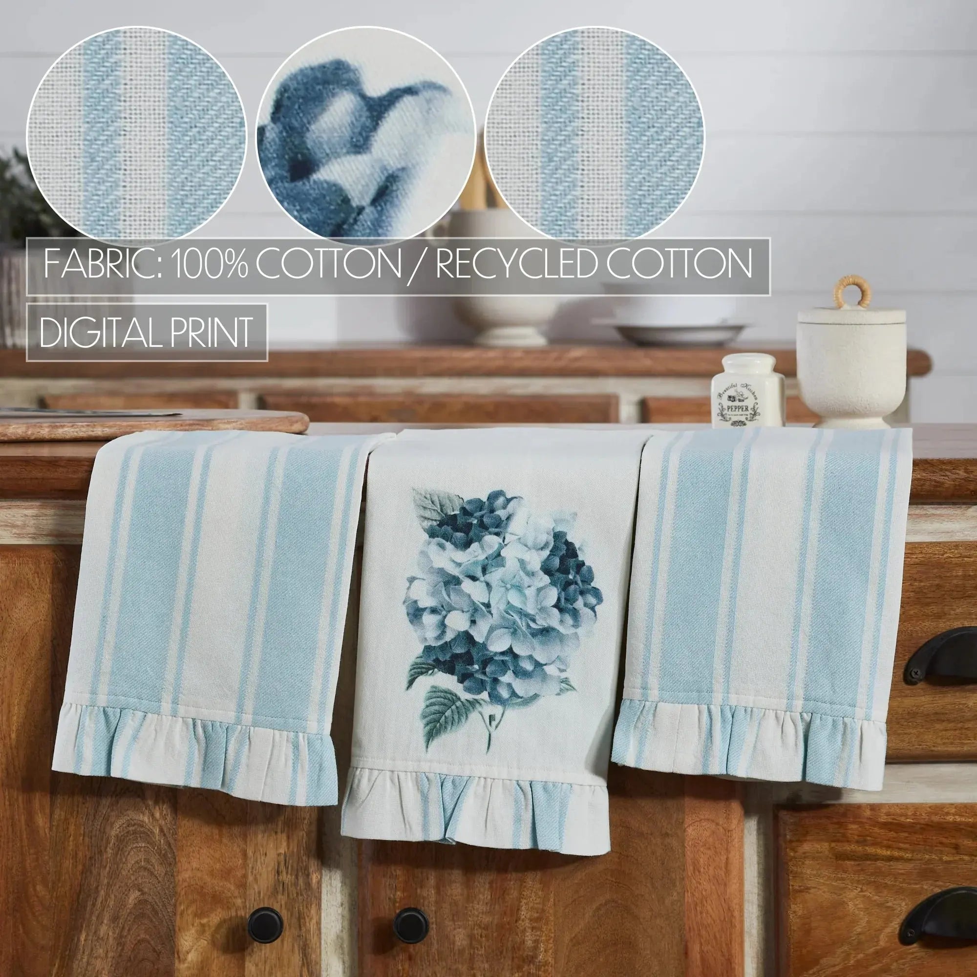 Set of three towels with blue and white patterns on a wooden surface