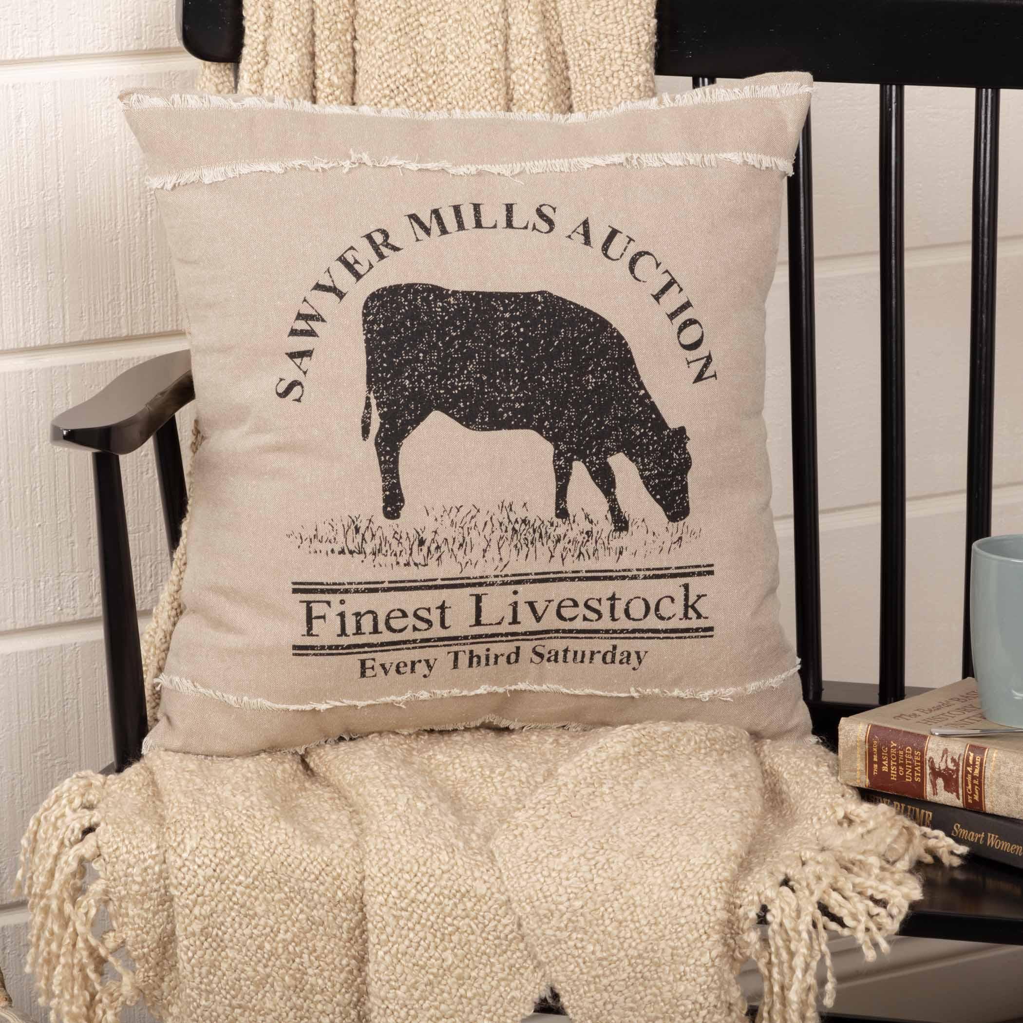 Decorative pillow with cow silhouette and text on a chair