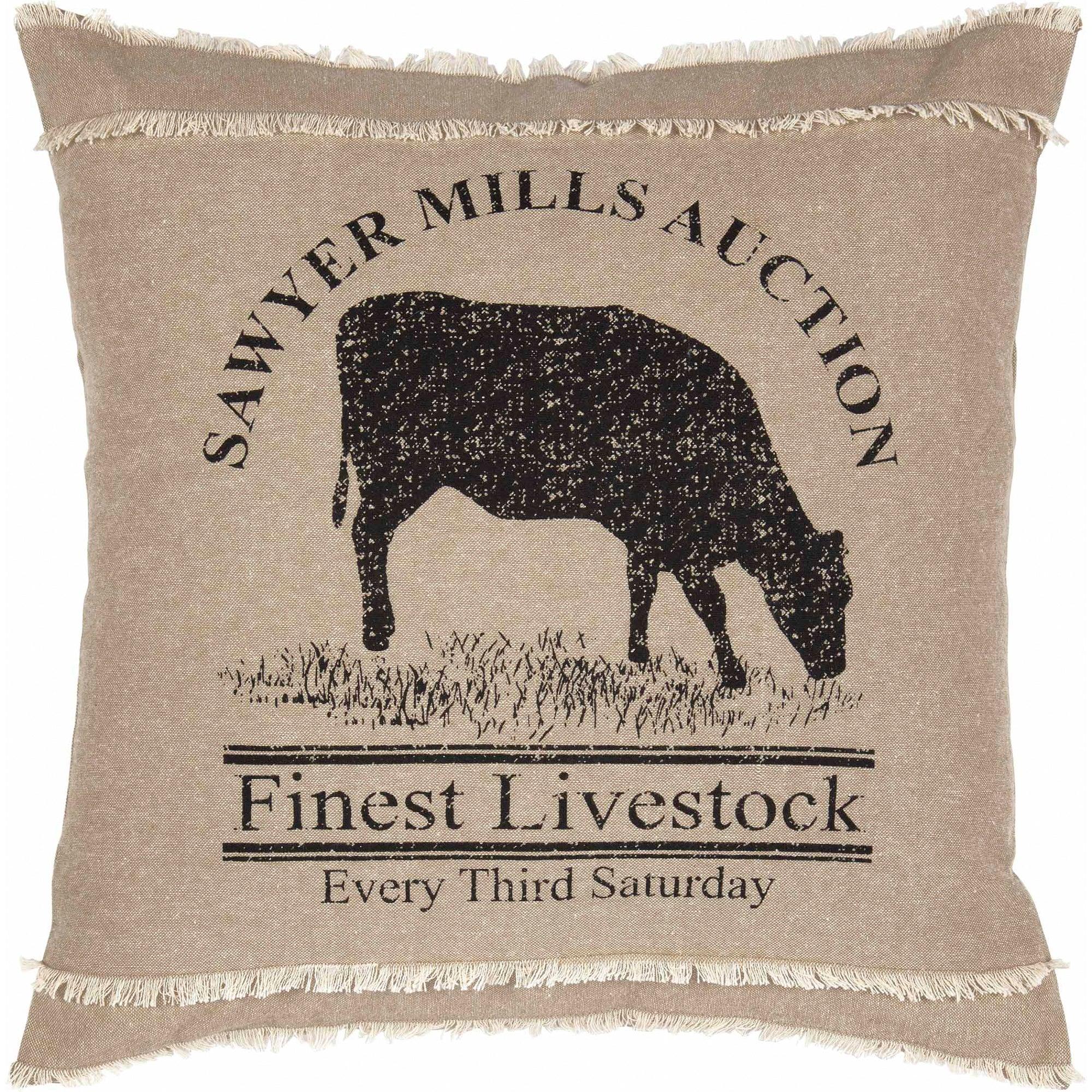 Pillow with cow silhouette and text 'Sawyer Mills Auction Finest Livestock Every Third Saturday' on beige background