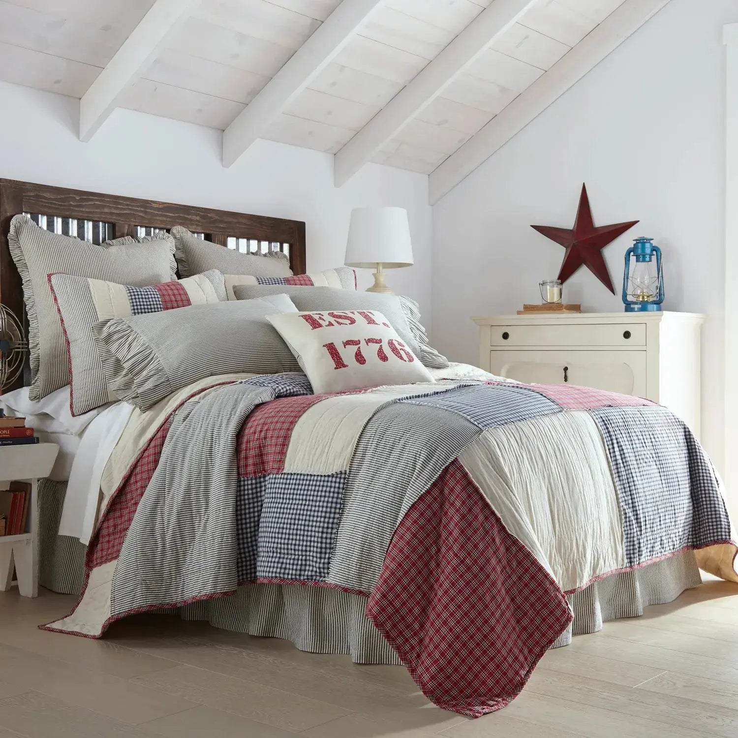 Cozy farmhouse bedroom with patchwork quilt, striped pillows, and rustic decor