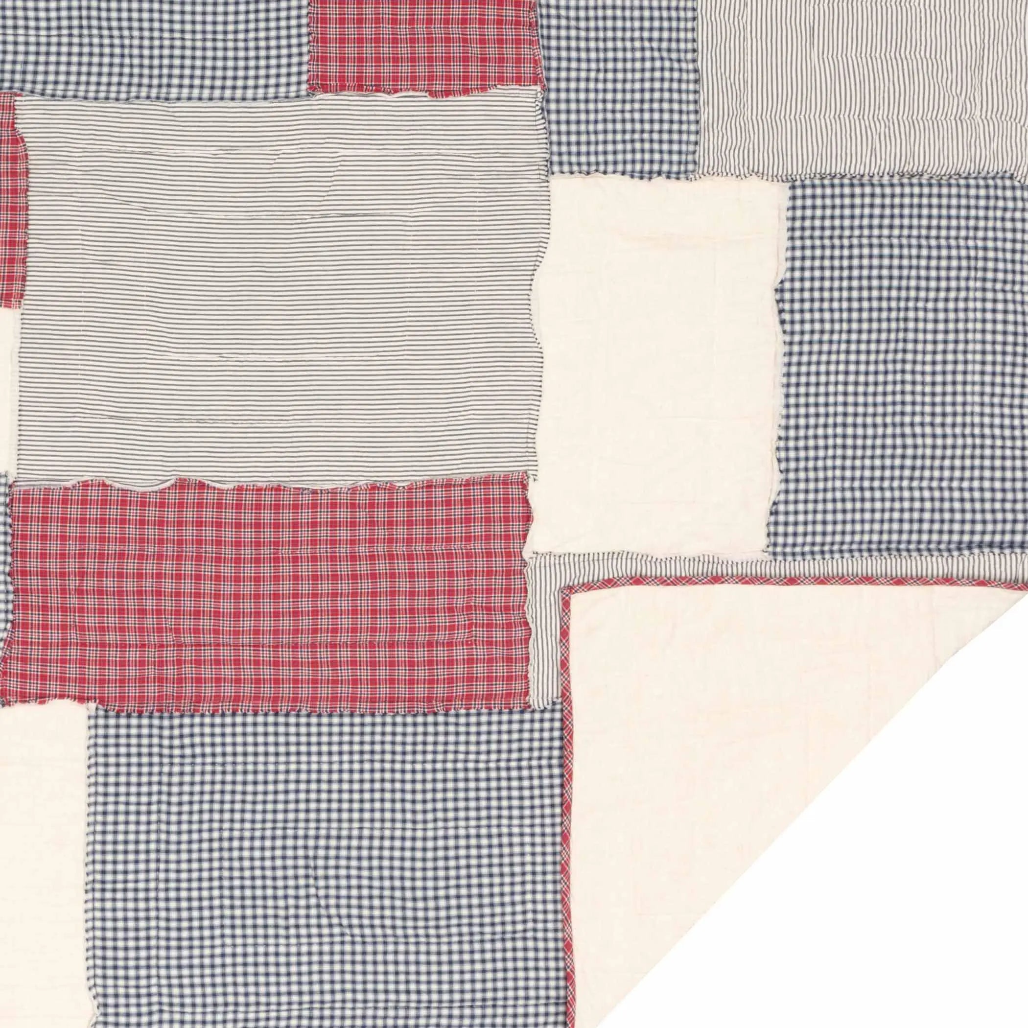 Cozy patchwork quilt with red plaid, blue gingham, and striped cotton squares for farmhouse decor