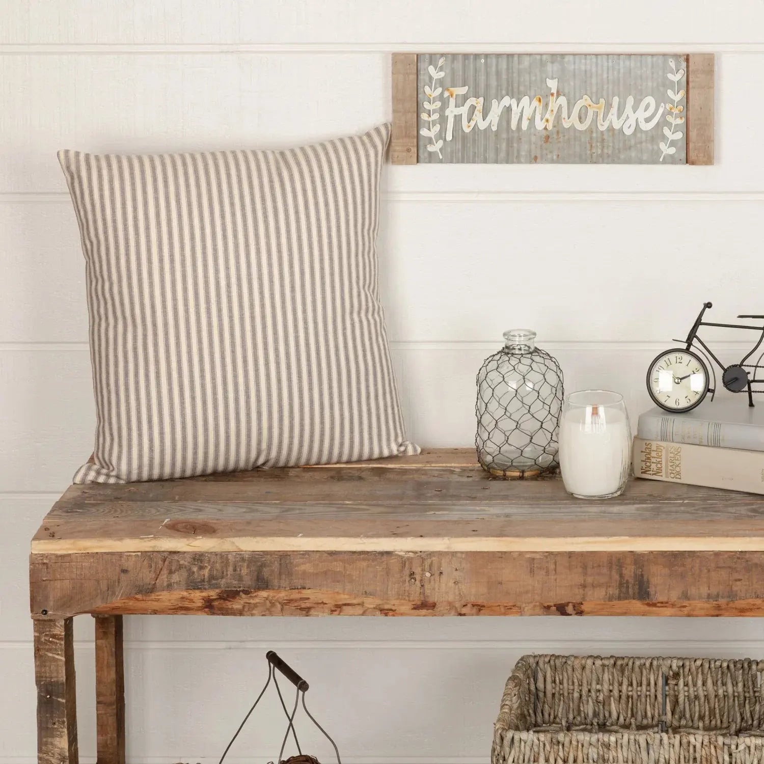 Farmhouse decor with striped pillow, rustic wood bench, candle, and 'Farmhouse' wall sign