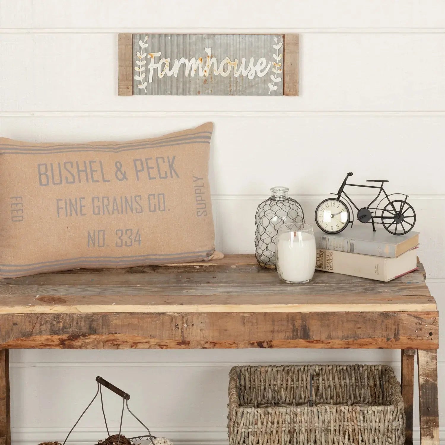 Farmhouse decor with rustic wood sign, burlap pillow, candle, and vintage bicycle clock on console table