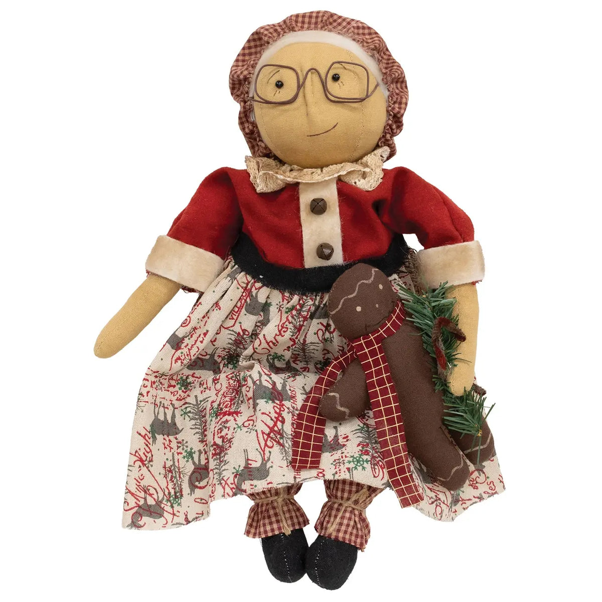 A rustic Christmas hanging doll with a beige face and hands, wearing a red top, patterned skirt, and brown plaid bonnet, holding a brown gingerbread figure and green pine sprigs against a white background.