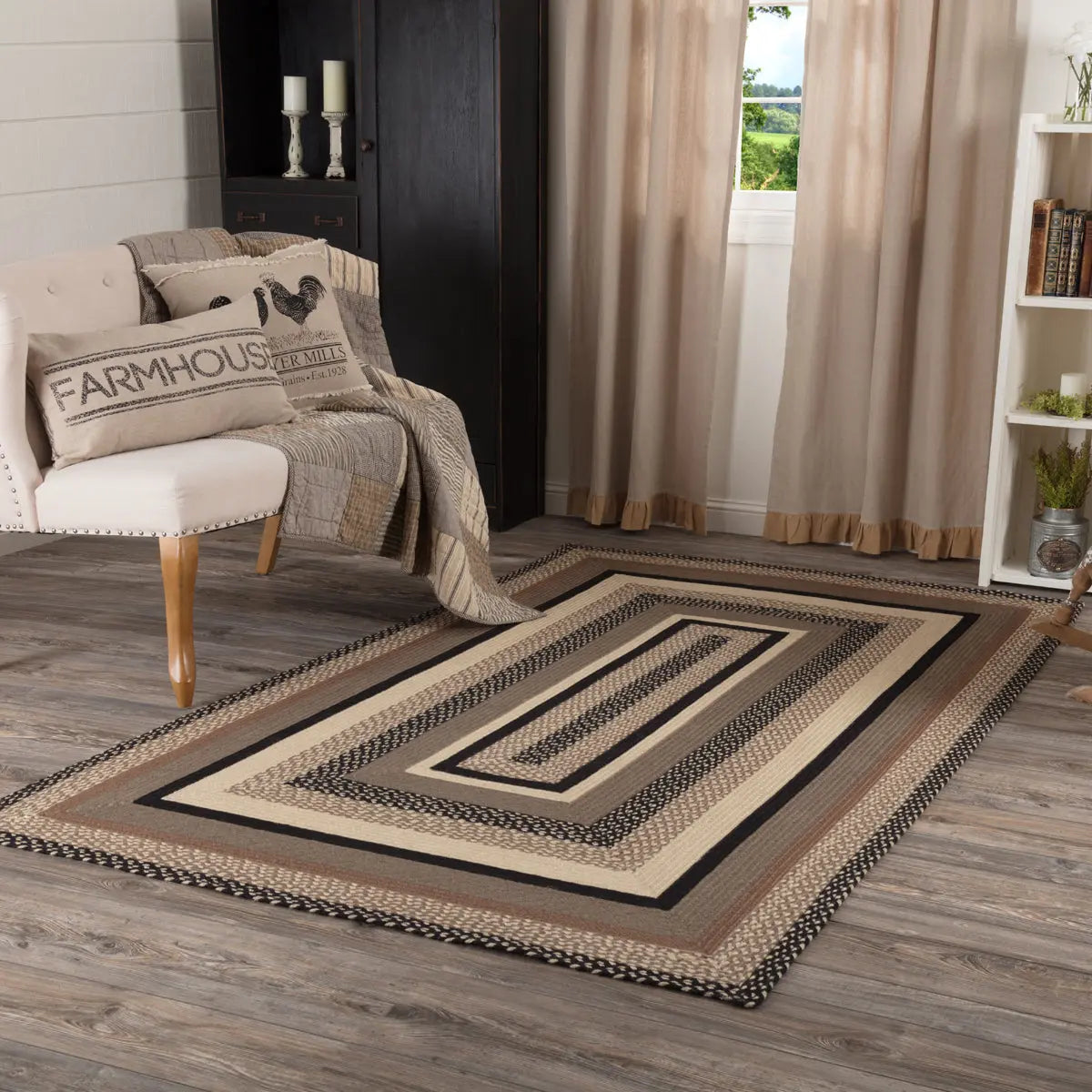 Living room with a patterned rug, chair, and decorative pillows.
