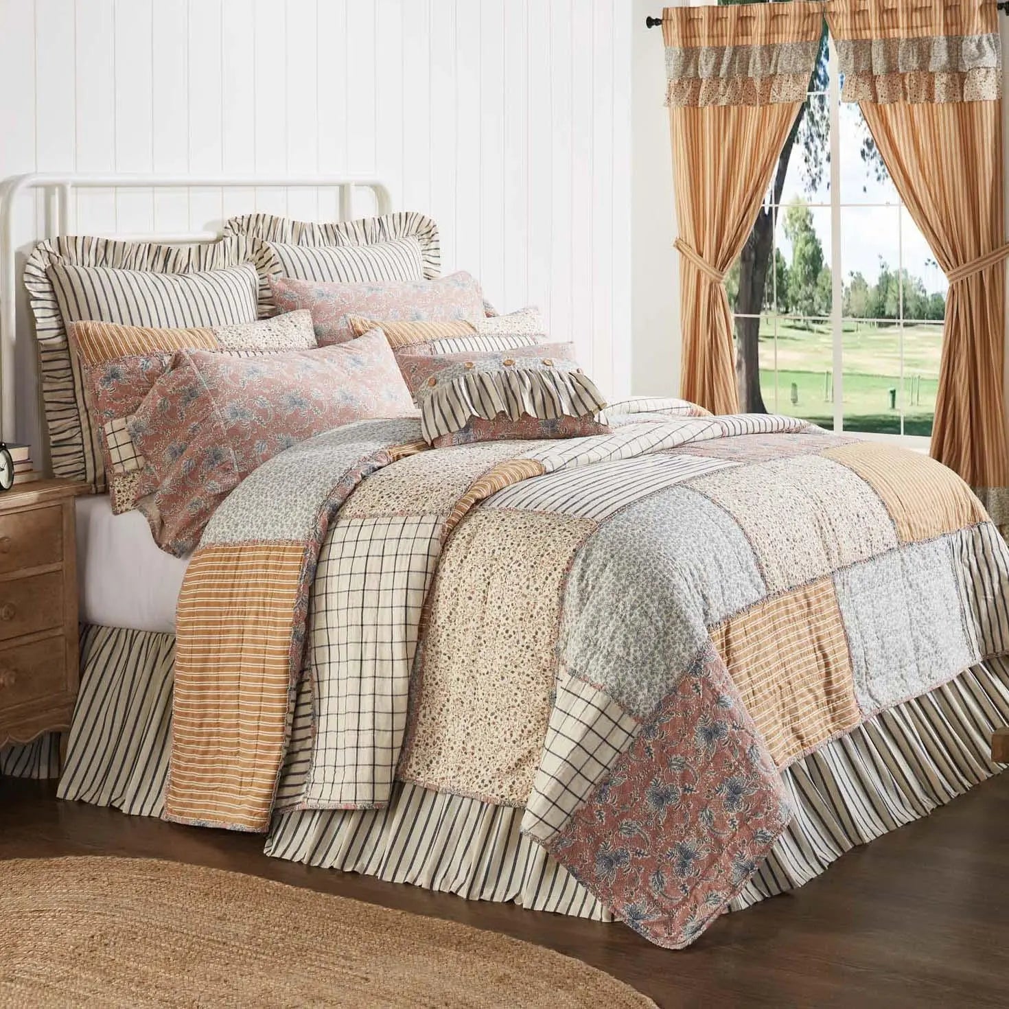 Cozy farmhouse patchwork quilt set with ruffled pillows and striped bedding in warm tones