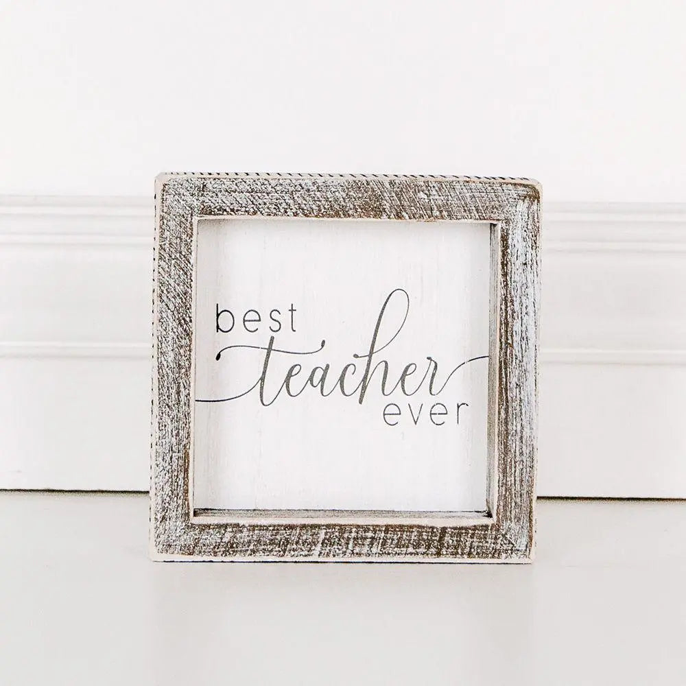 Framed sign with 'best teacher ever' text on a white wooden background