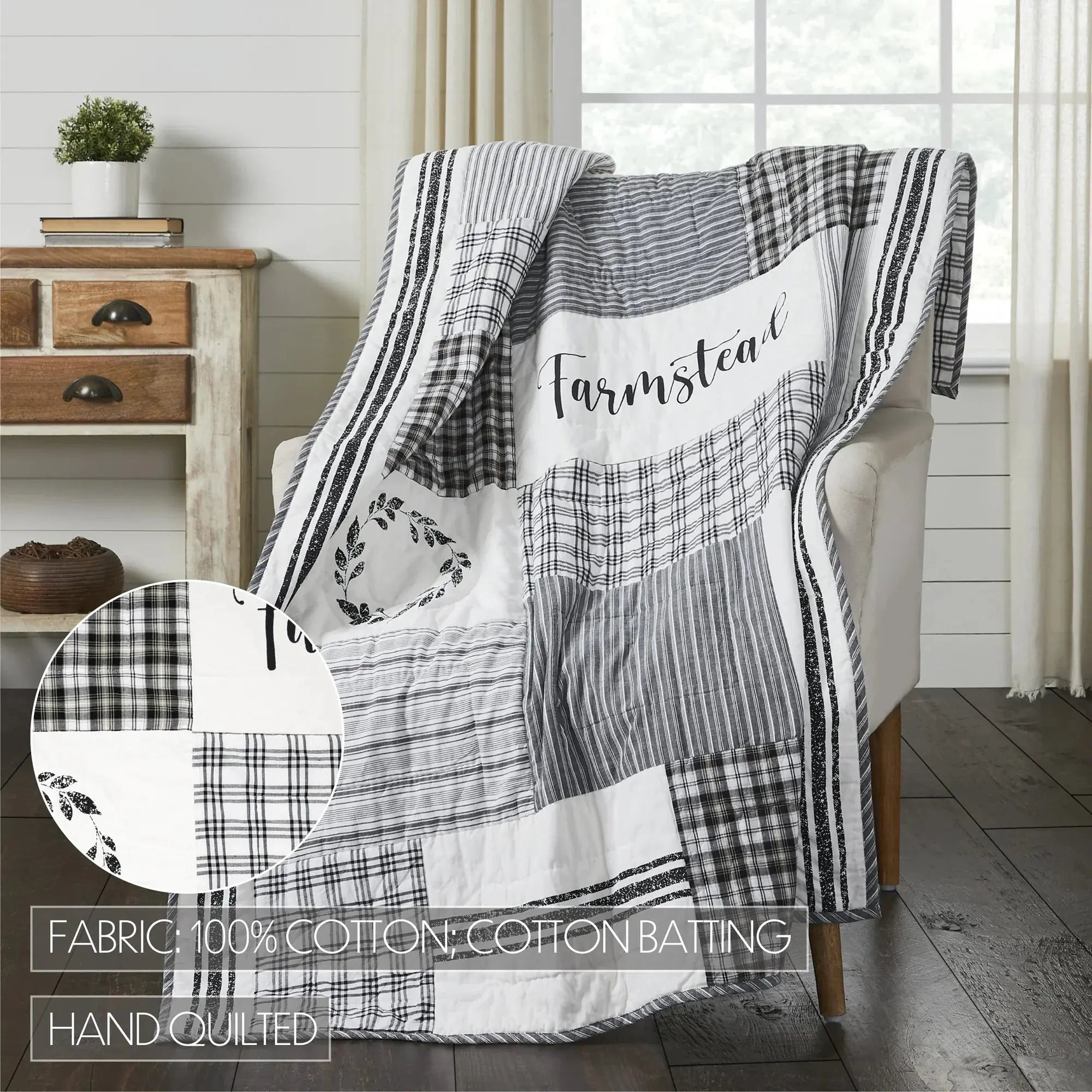 Patchwork blanket with 'Farmstead' text draped over a chair in a room with wooden furniture and a window.