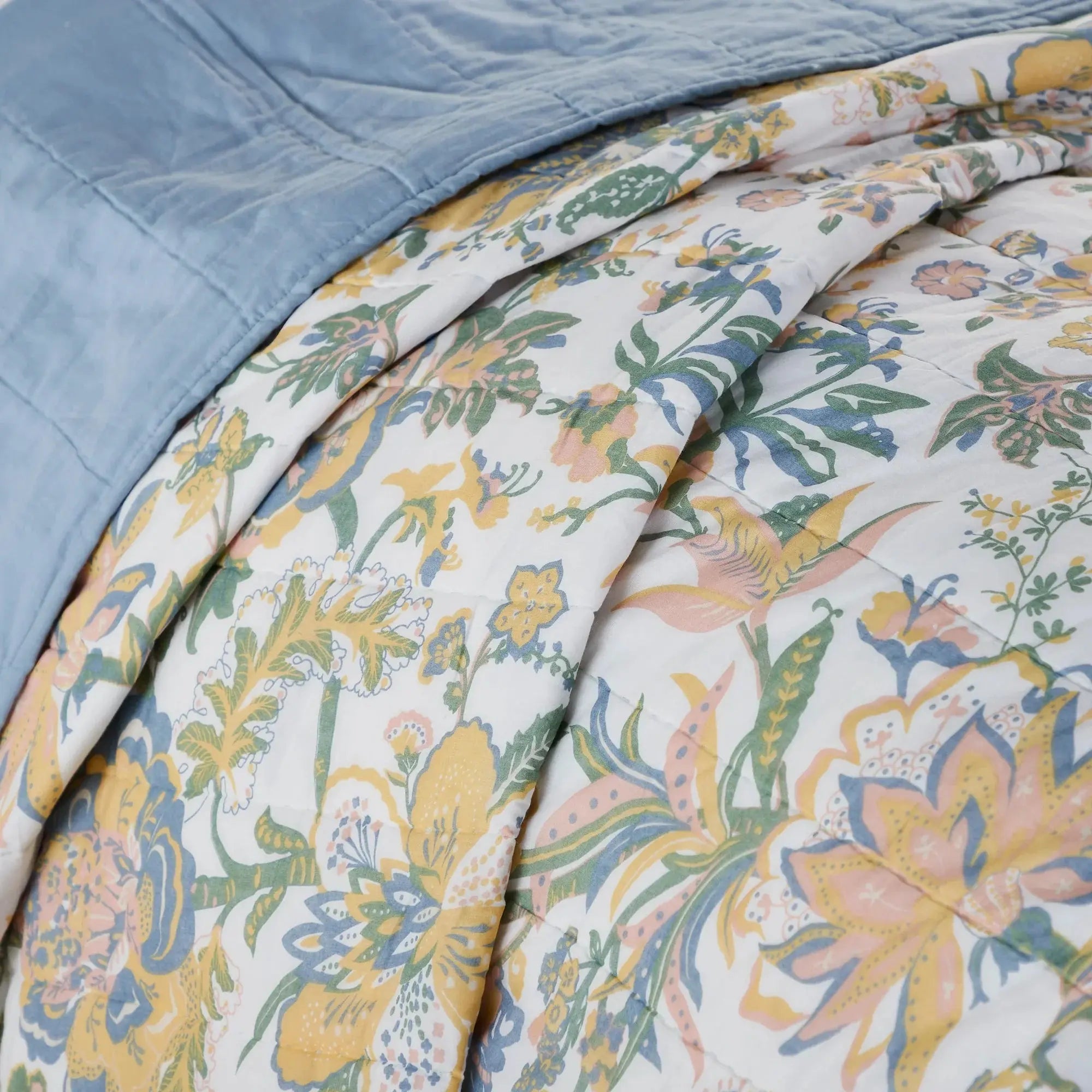 Floral quilt with yellow, blue, and green botanical print, cozy farmhouse style bedding