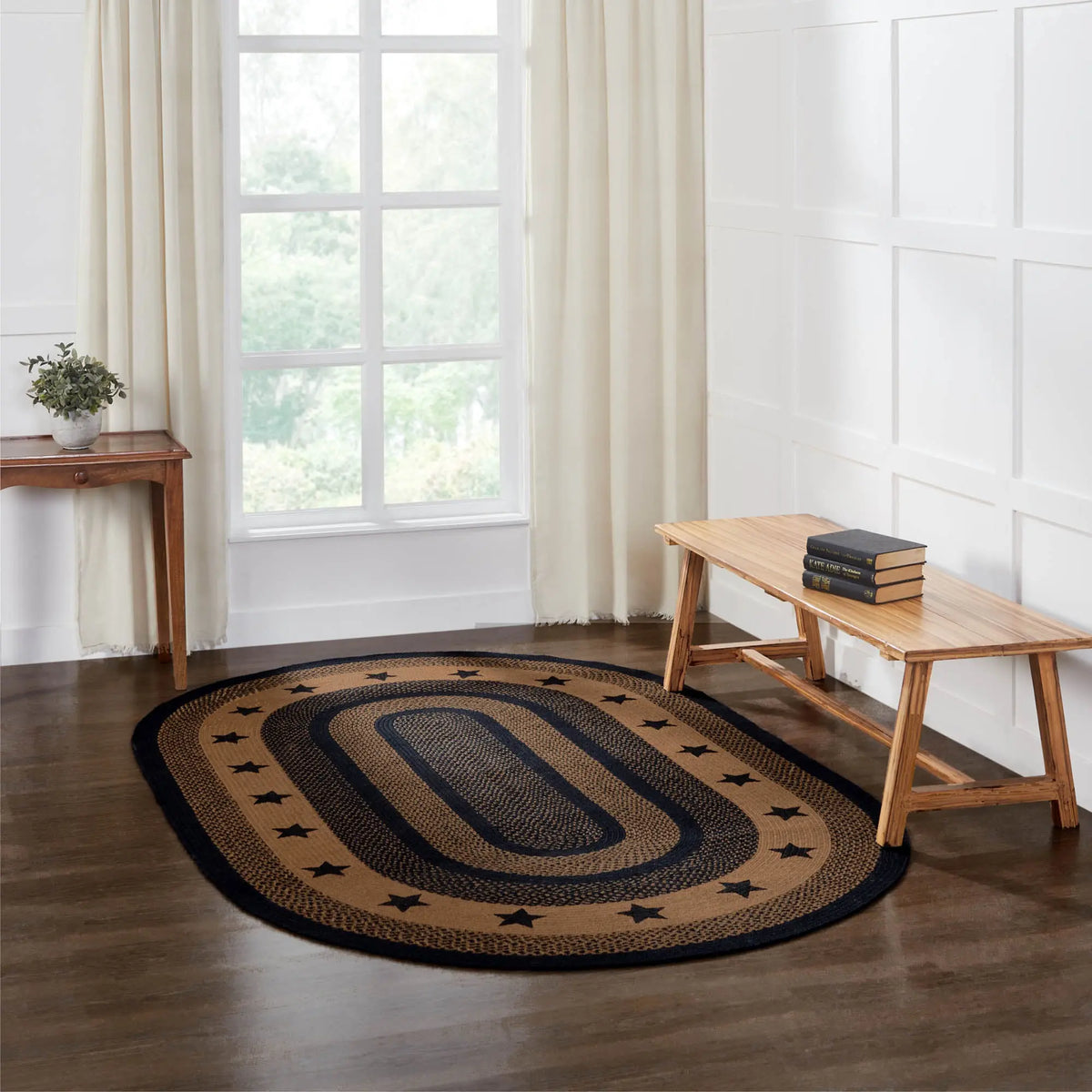 Round braided rug with star pattern on a wooden floor in a bright room.