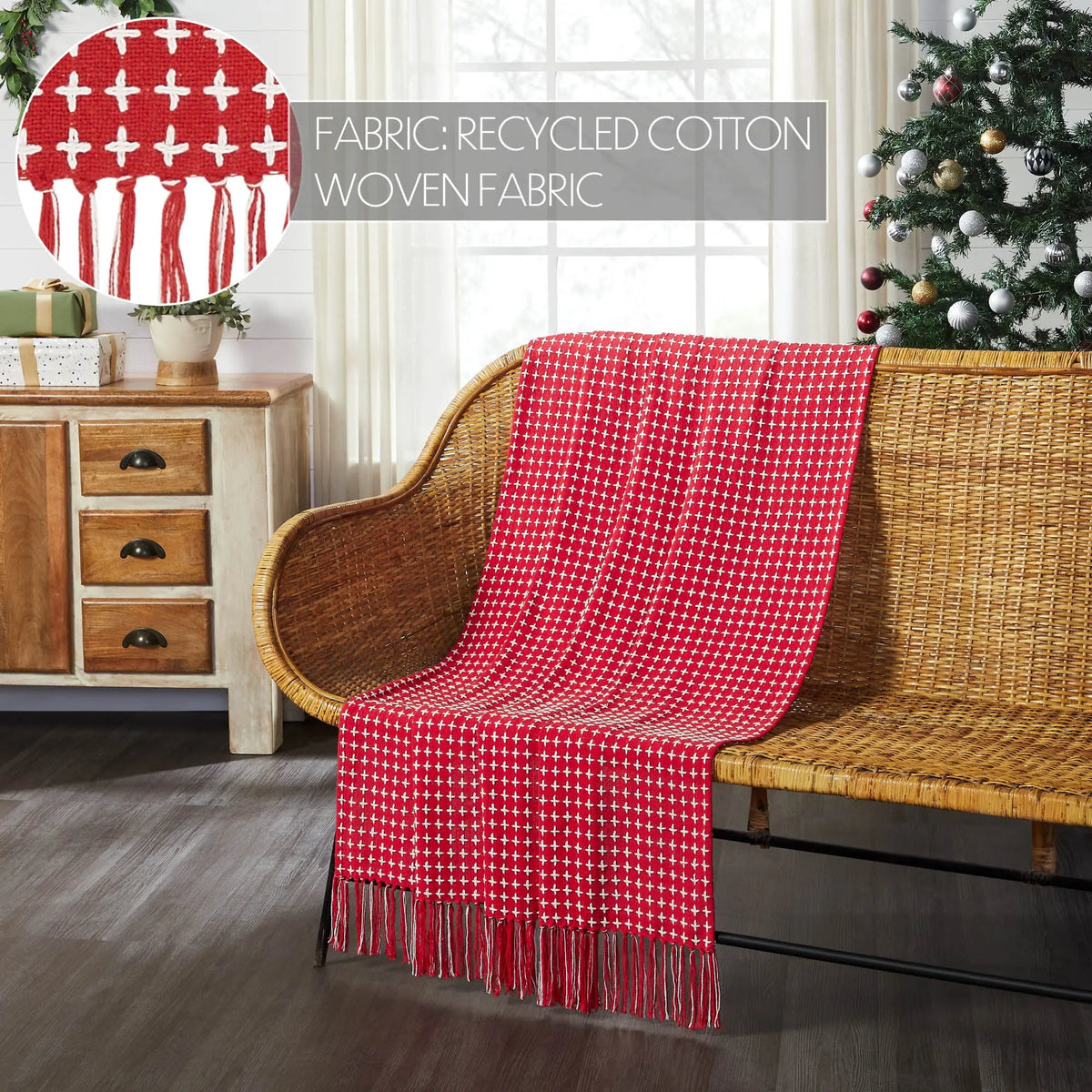 Red checkered blanket draped over a wicker chair in a room with a Christmas tree and wooden dresser.