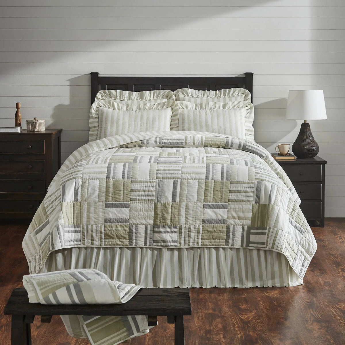 Bed with green and white geometric patterned comforter in a bedroom setting.