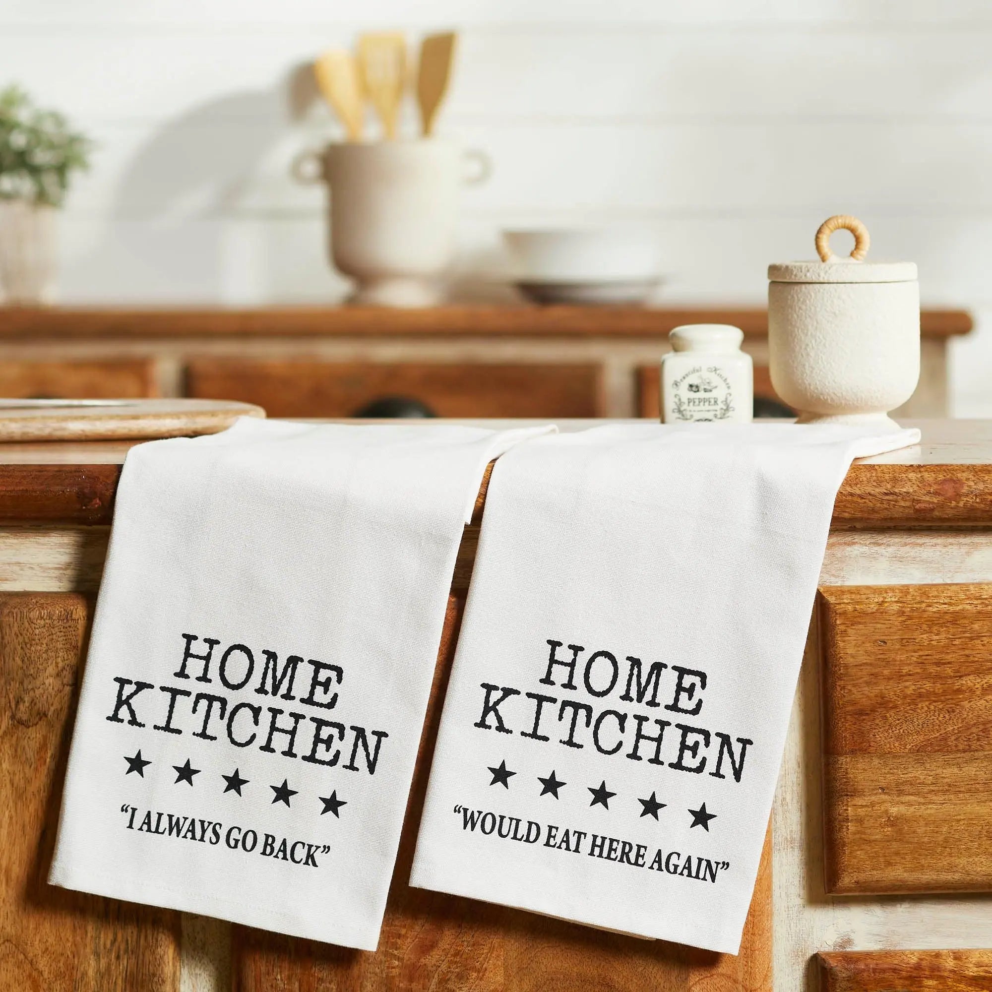 Two kitchen towels with 'Home Kitchen' text on a wooden surface.