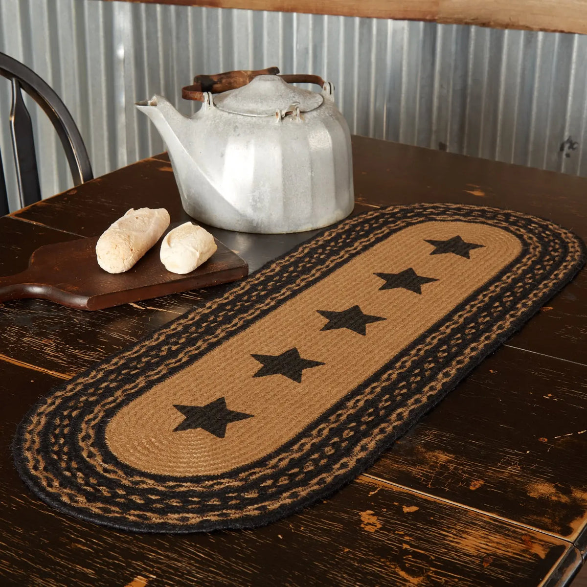 Table runner with star pattern on a wooden table with a teapot and bread.