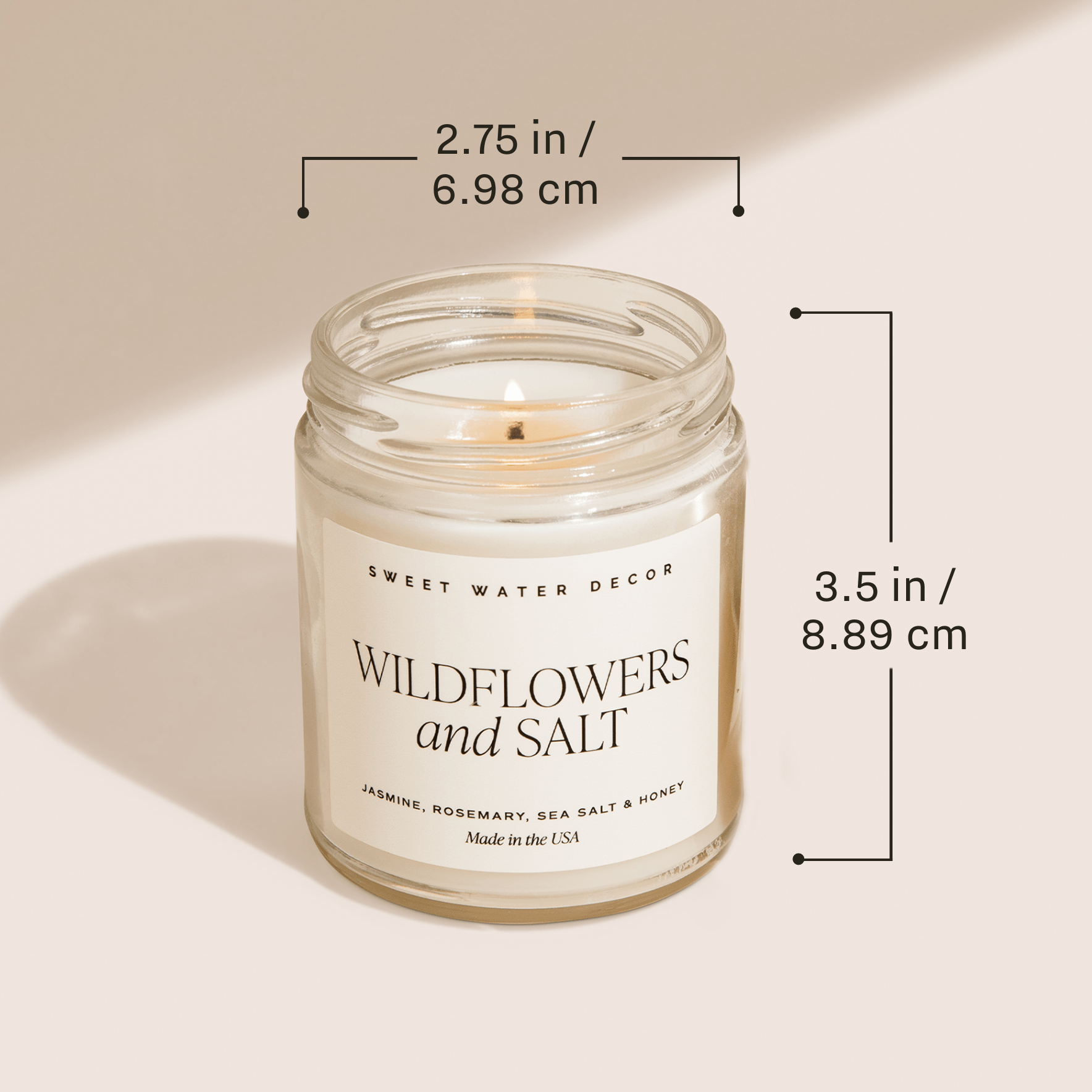 Candle in a glass jar with dimensions labeled on a beige background