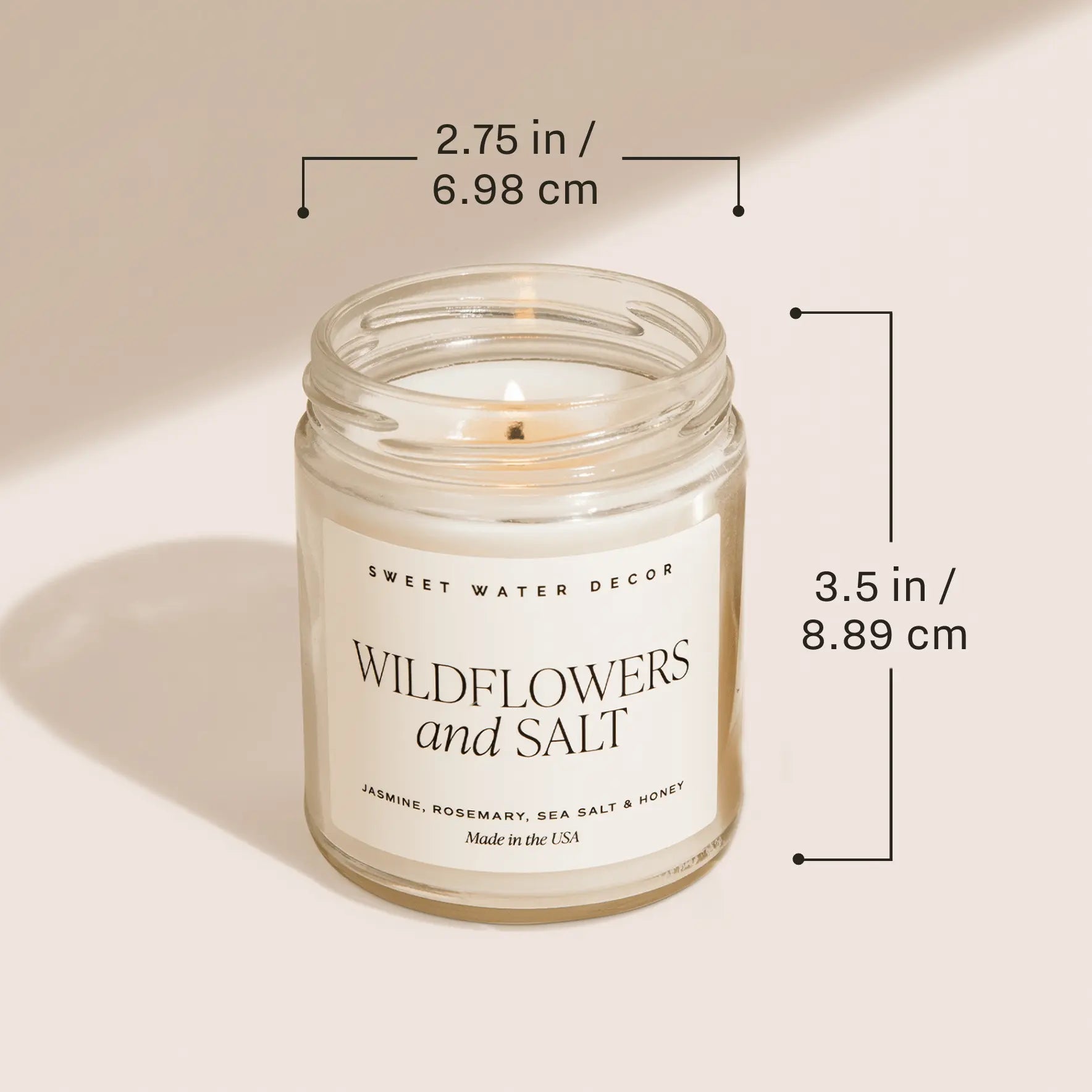 Candle in a glass jar with dimensions labeled on a beige background