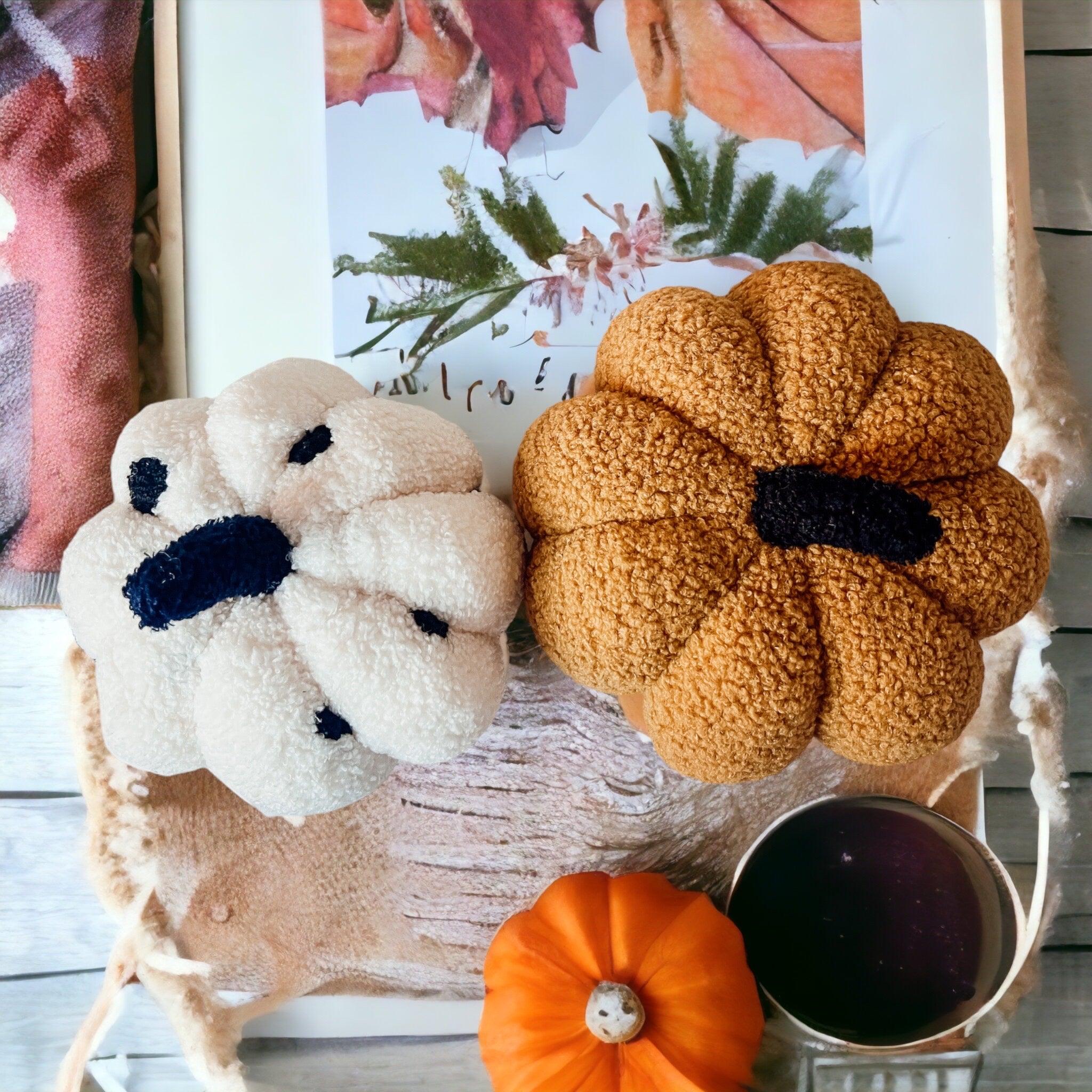 Decorative items including a plush dog, pumpkin, and small container on a wooden surface.