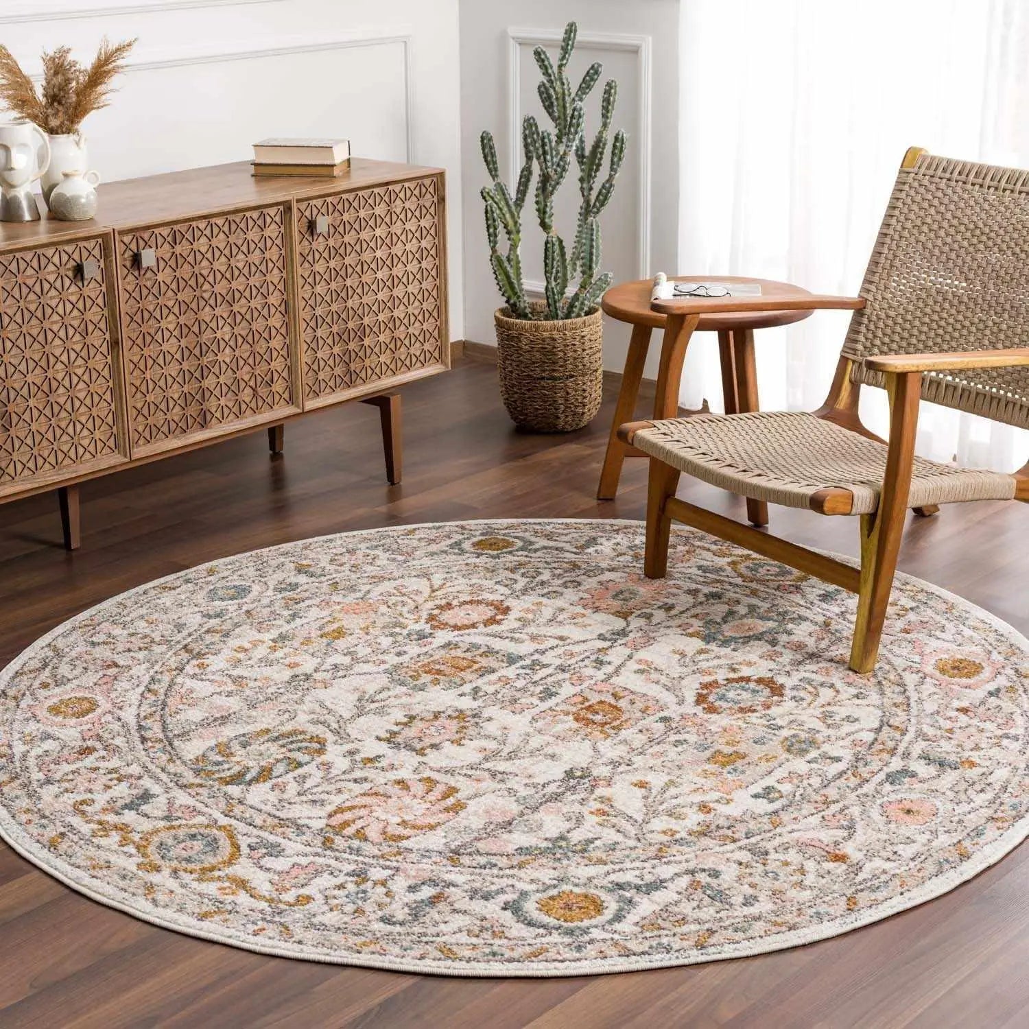 Round floral rug in cozy farmhouse living room with wicker chair and wooden sideboard