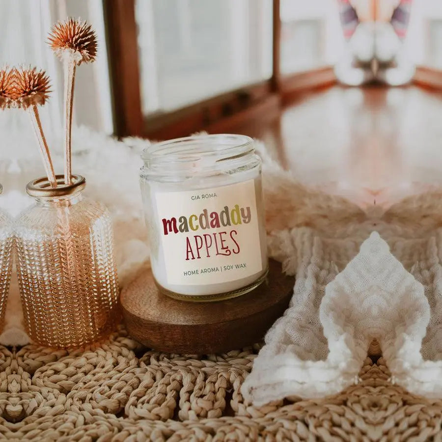 Candle labeled 'comfy & cozy' on a textured surface with decorative elements.
