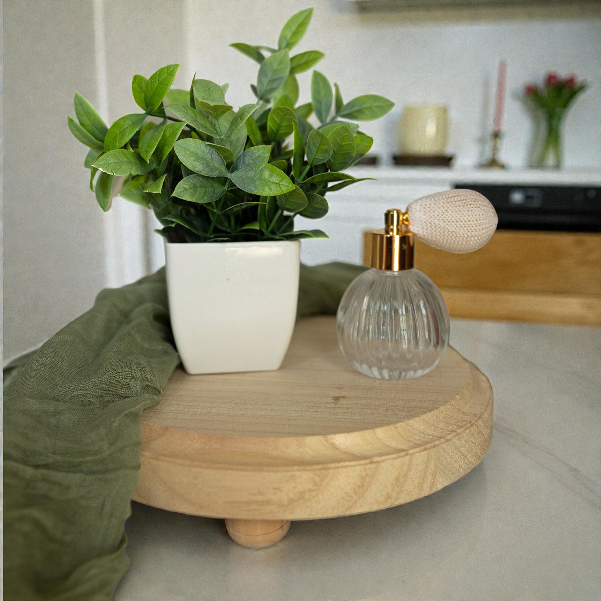 Small potted plant and decorative bottle on a wooden surface with a blurred indoor background