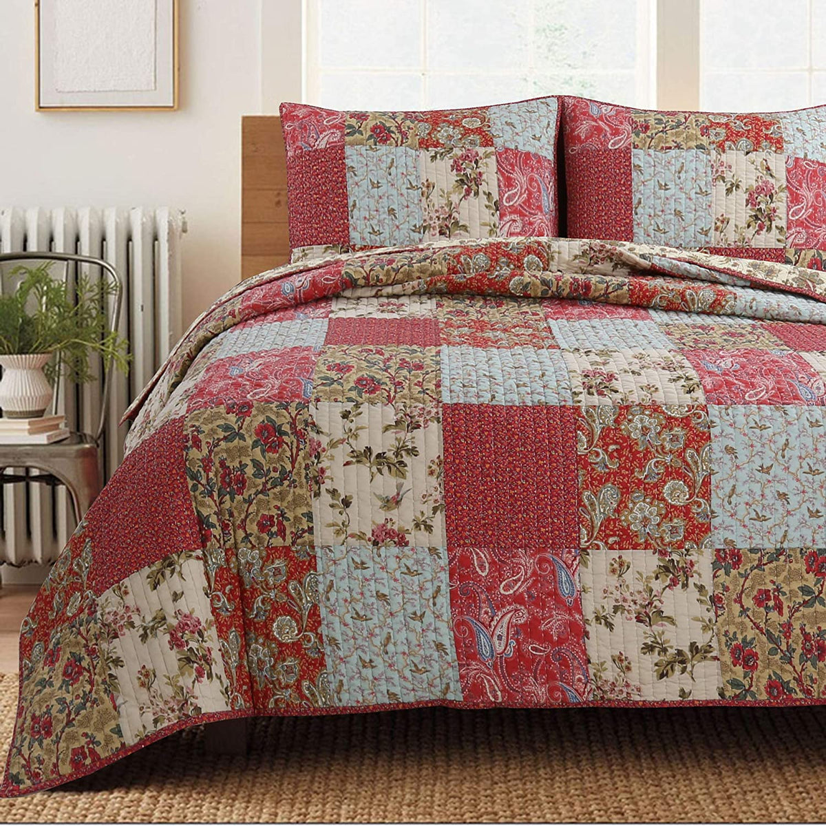 Patchwork quilt with floral patterns on a bed in a room with a radiator and window.