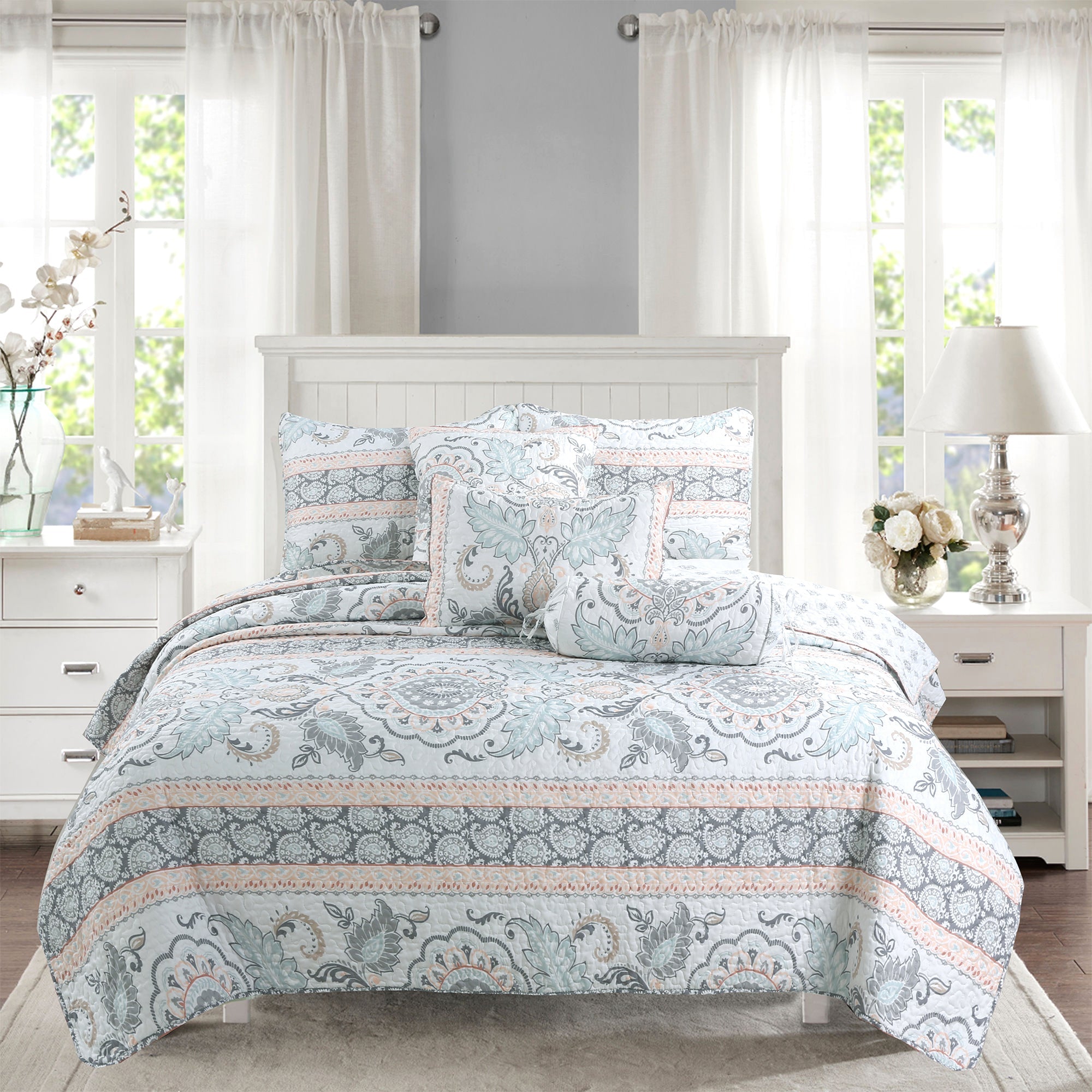 Peach paisley floral reversible quilt bedding set with aqua blue and grey accents on a farmhouse style bed.