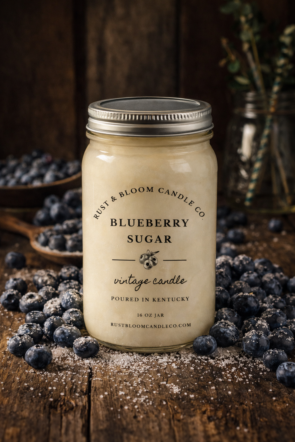 Jar of Blueberry Sugar candle from Rust & Bloom Candle Co surrounded by blueberries on a wooden surface.