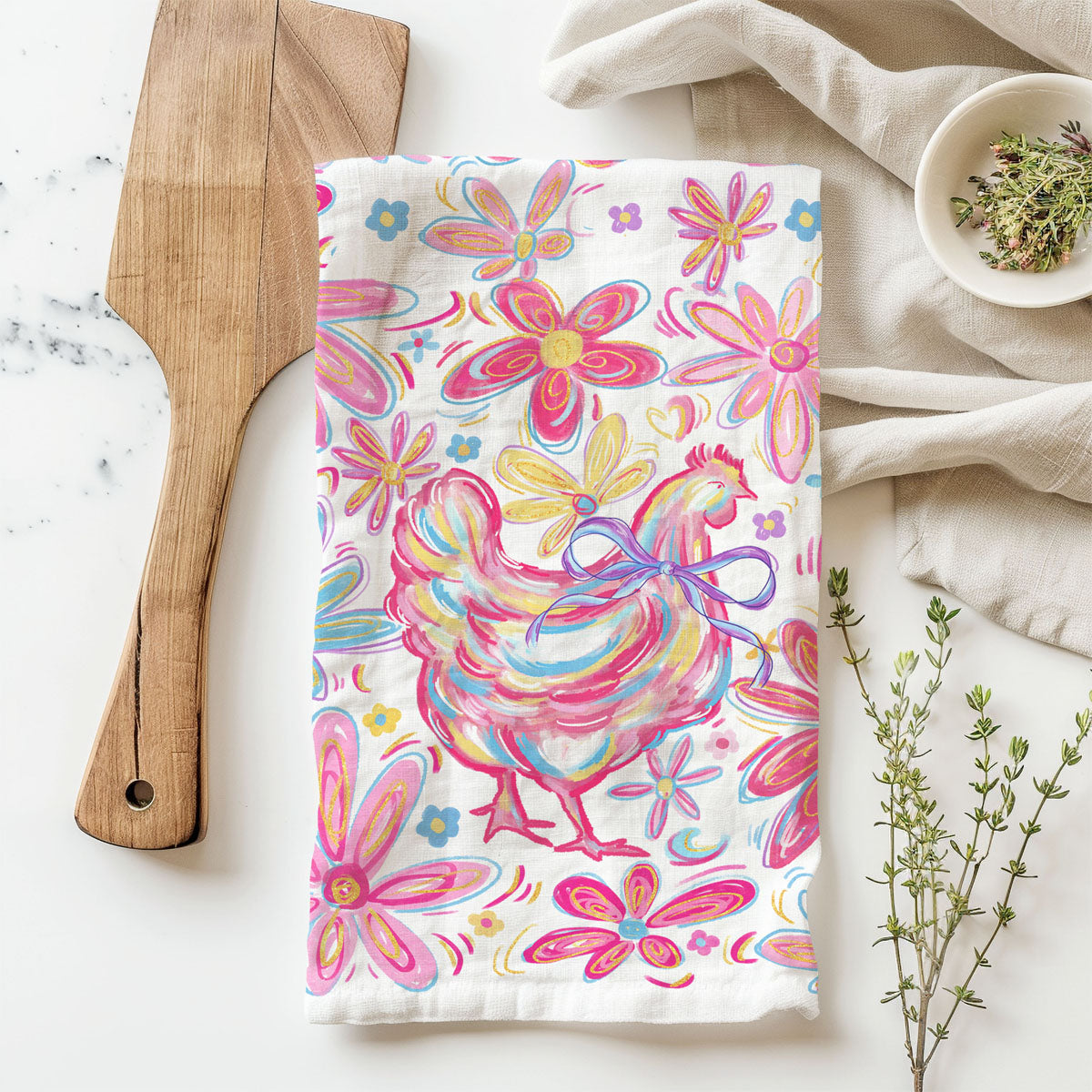 Colorful towel with rooster and floral design on a kitchen counter.