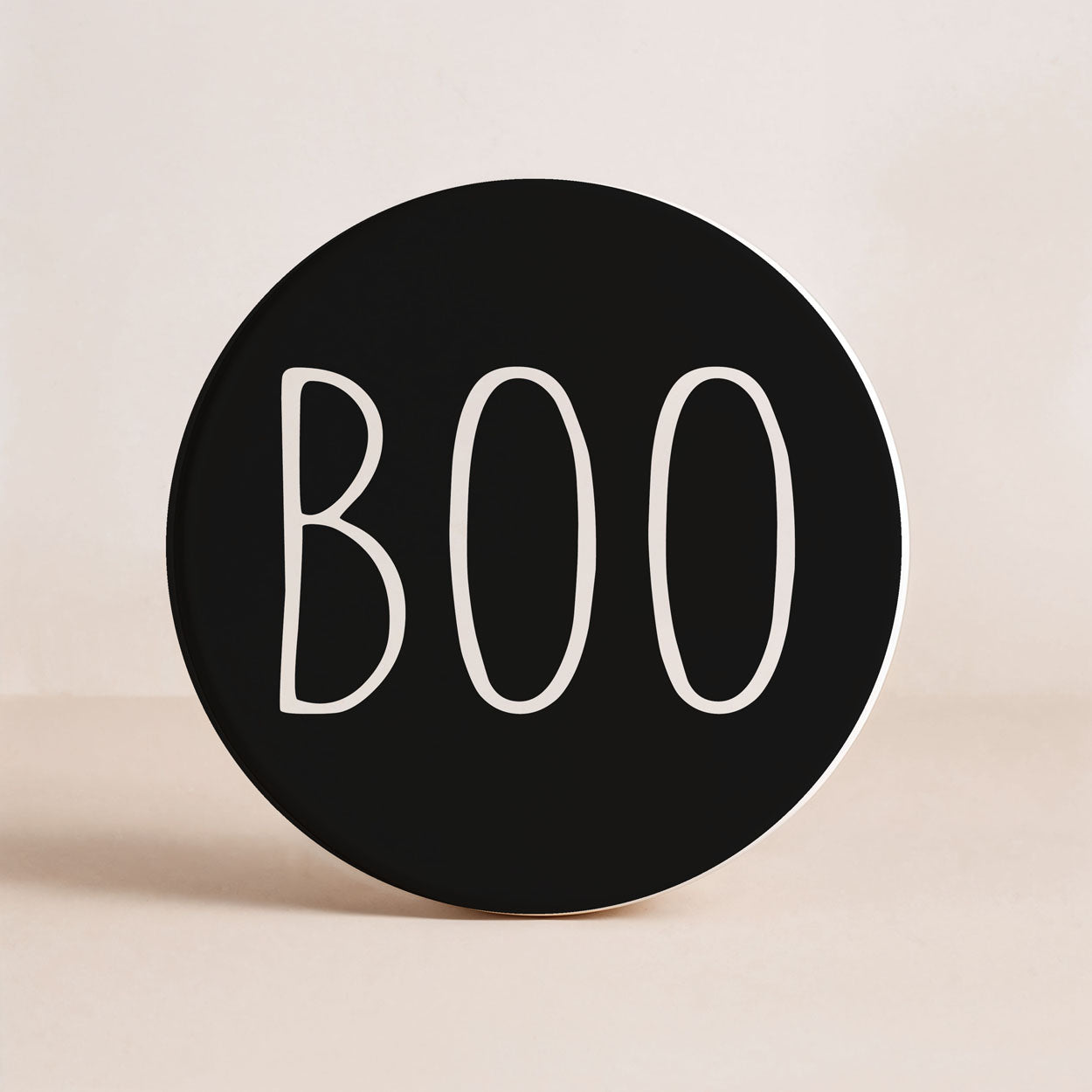 Black circular sign with 'BOO' text on a beige background