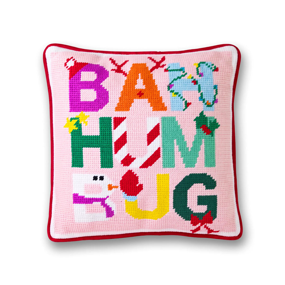 A square pink needlepoint pillow with a red border, featuring the words 'BAM BUM' spelled out in colorful, festive letters with holiday motifs like candy canes, holly, and a snowman.