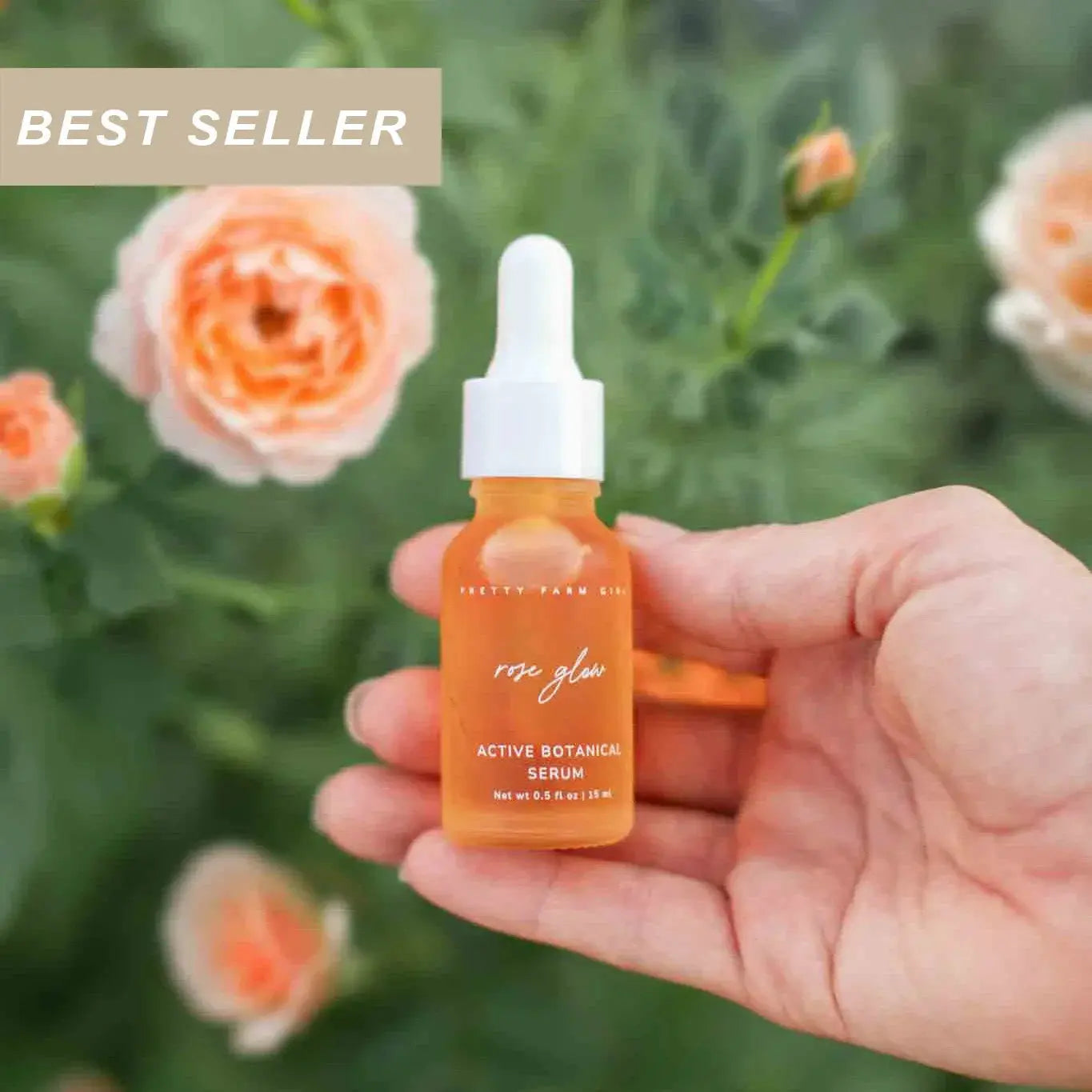 Hand holding rose glow active botanical serum bottle with peach roses, best seller