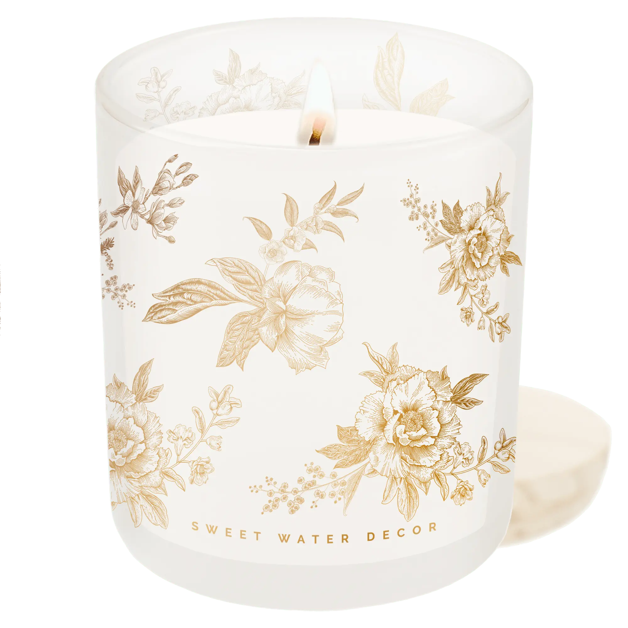 Lit floral candle in frosted glass with gold botanical print, cozy farmhouse decor