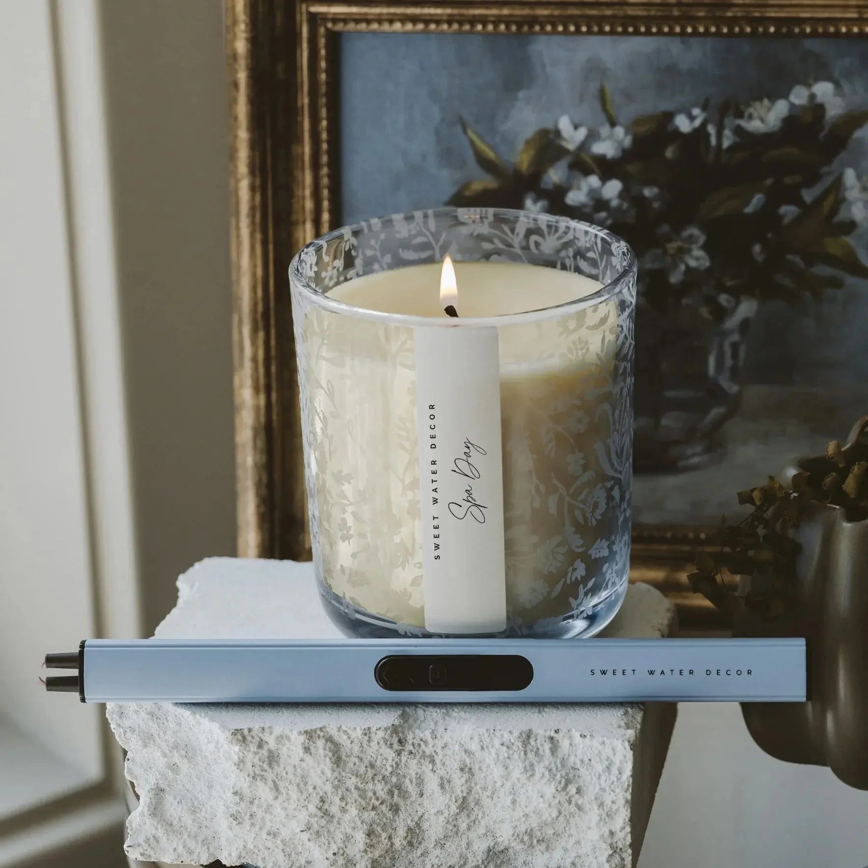 Lit 'Spa Day' candle in floral glass jar with lighter, cozy farmhouse decor