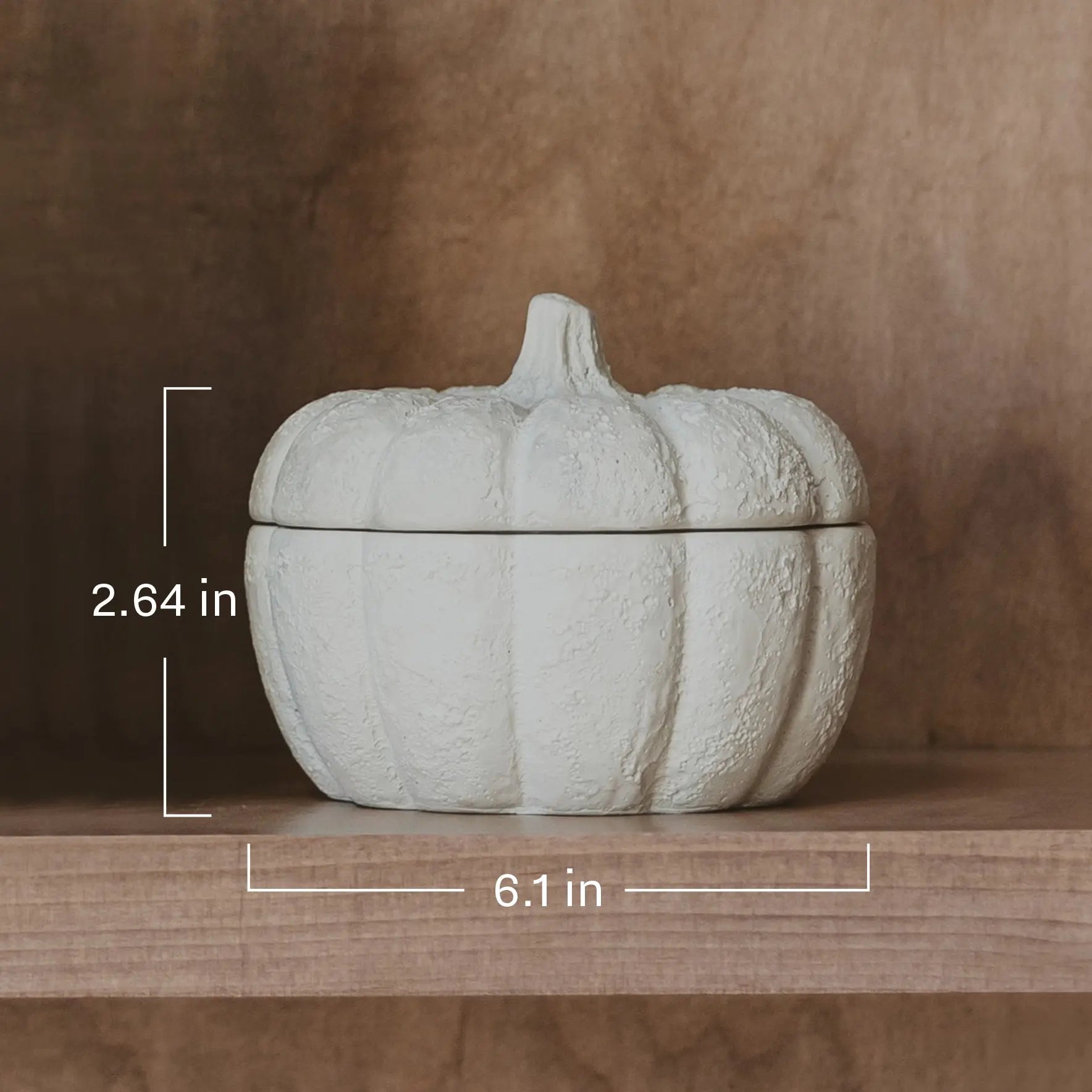 White pumpkin-shaped container with dimensions on a wooden surface