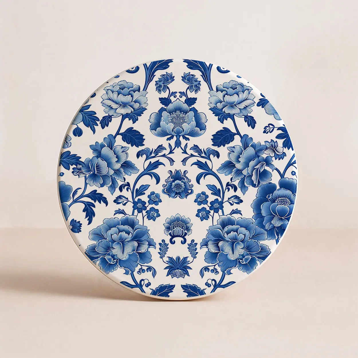 Ceramic coaster with blue floral pattern on a beige background