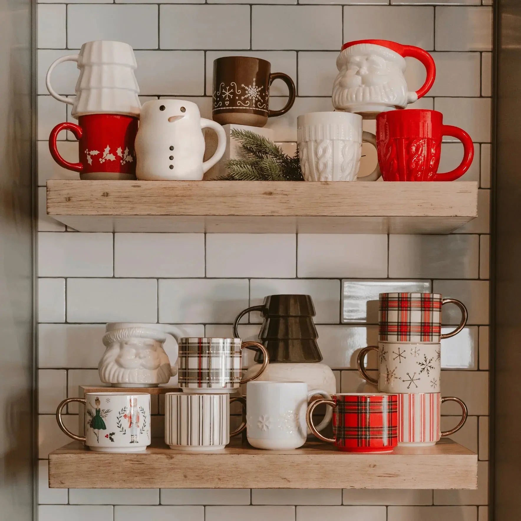 Festive holiday mugs with Santa, snowman, plaid, and snowflake designs on rustic shelves for cozy farmhouse decor