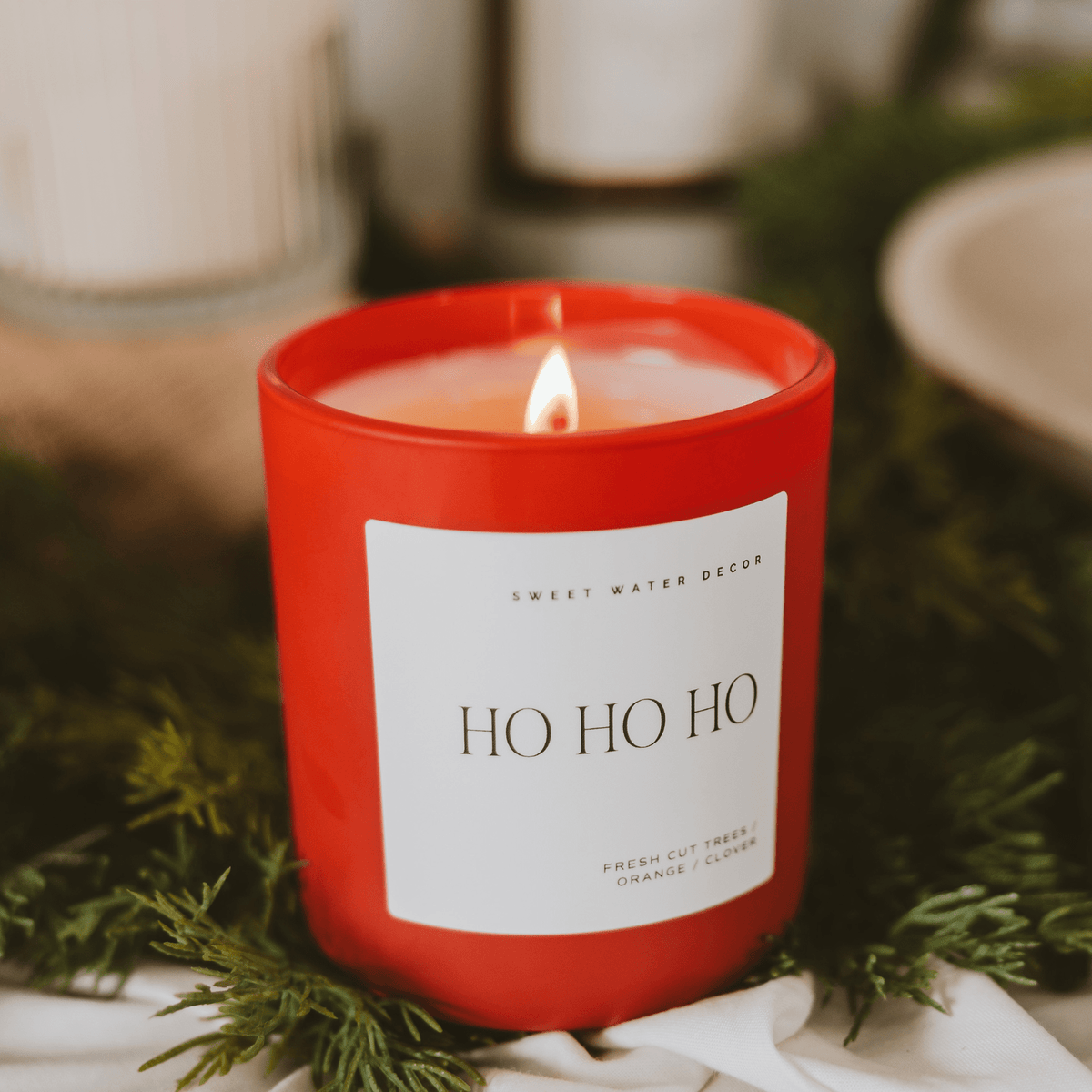 Red candle with 'HO HO HO' label on a white background