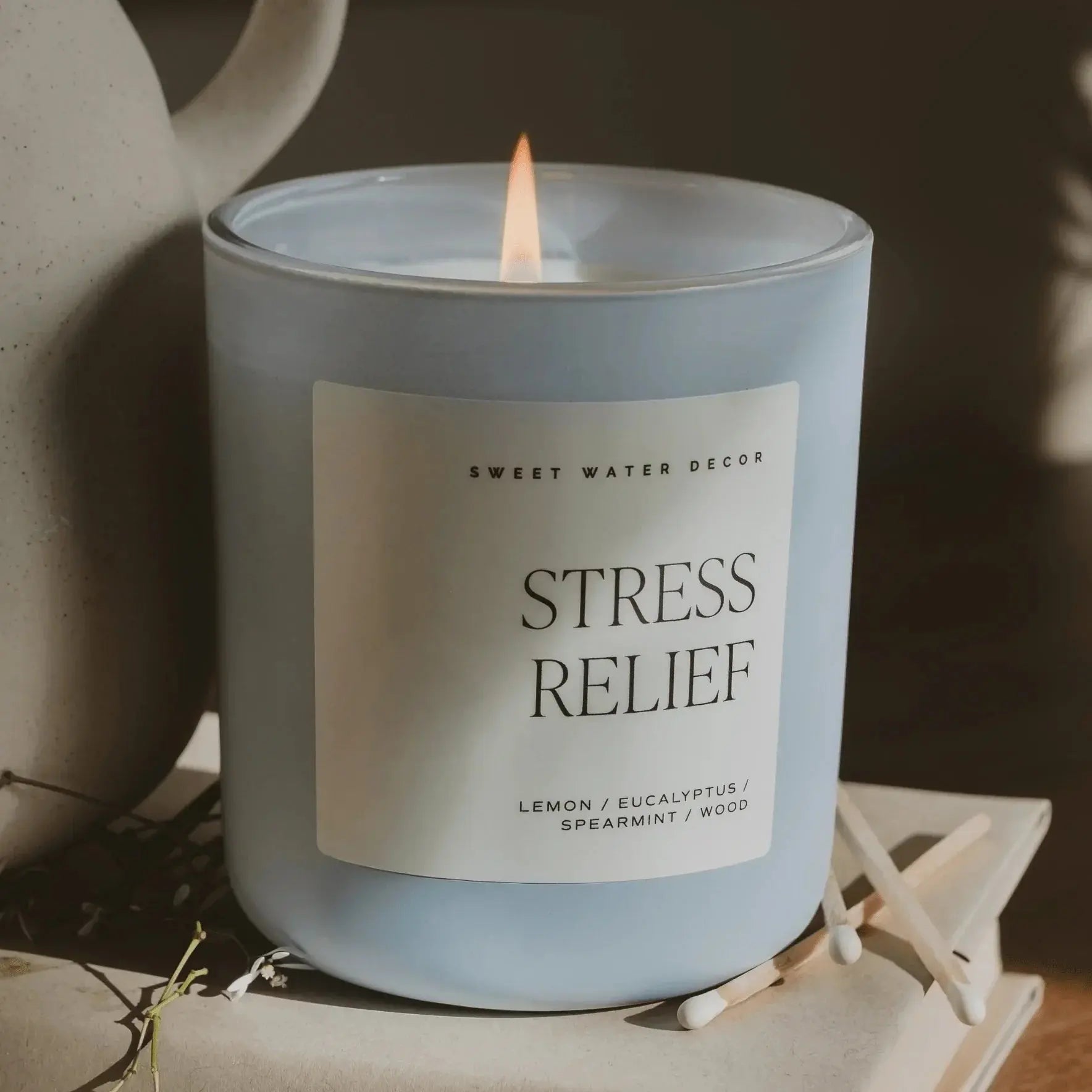 Lit stress relief candle with lemon eucalyptus spearmint wood scent, cozy farmhouse decor