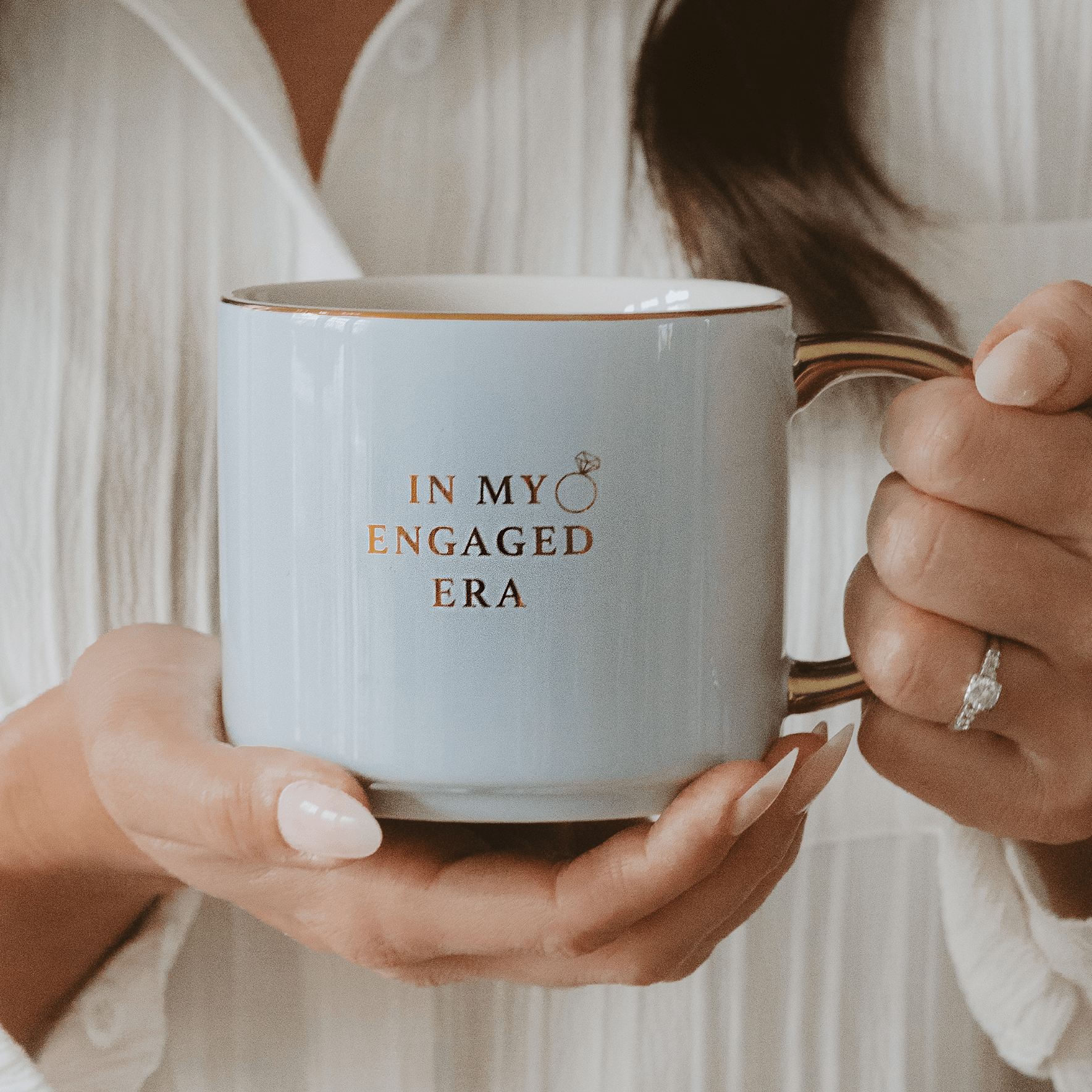 Person holding a mug with 'In My Engaged Era' text