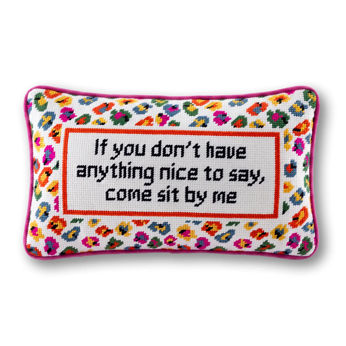 A rectangular cross-stitch cushion with a colorful floral border and a central white panel containing the embroidered text, 'If you don't have anything nice to say, come sit by me' in black. The cushion is finished with a pink border and is shown against a plain white background.