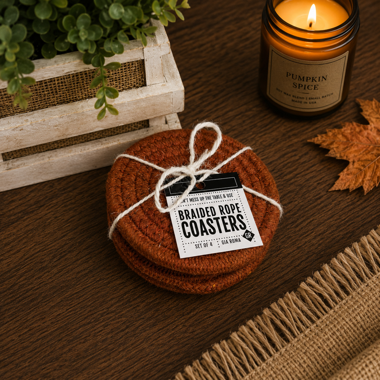 Set of braided rope coasters with a tag on a wooden surface next to a candle.