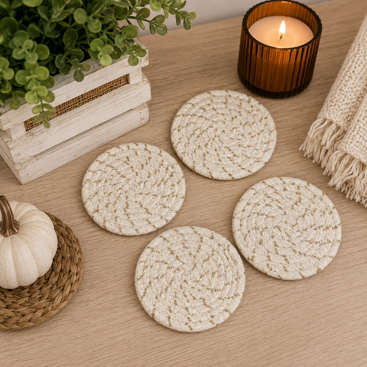 Set of woven coasters on a wooden surface with a candle and decorative items.