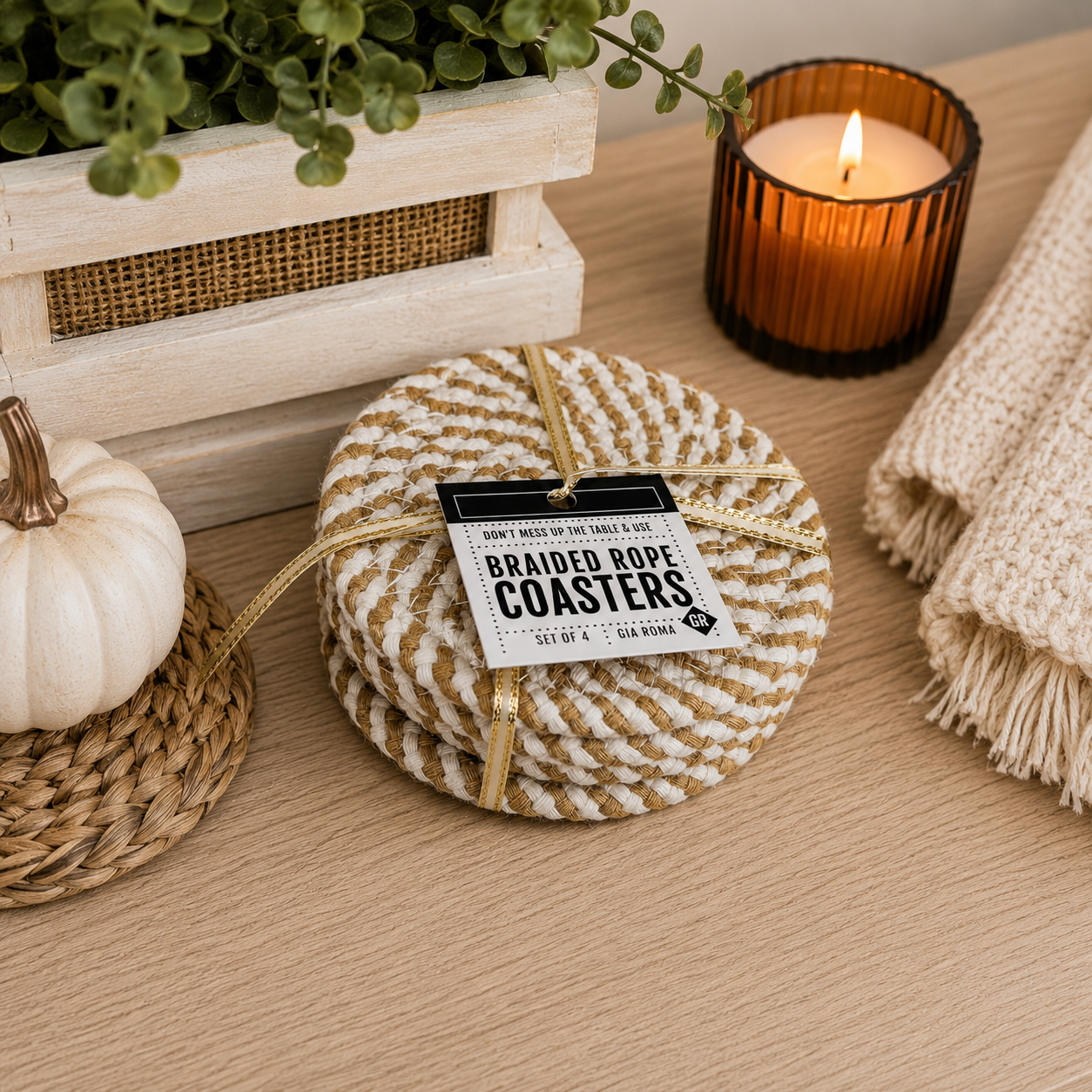 Set of braided rope coasters on a wooden surface with a candle and decorative items.