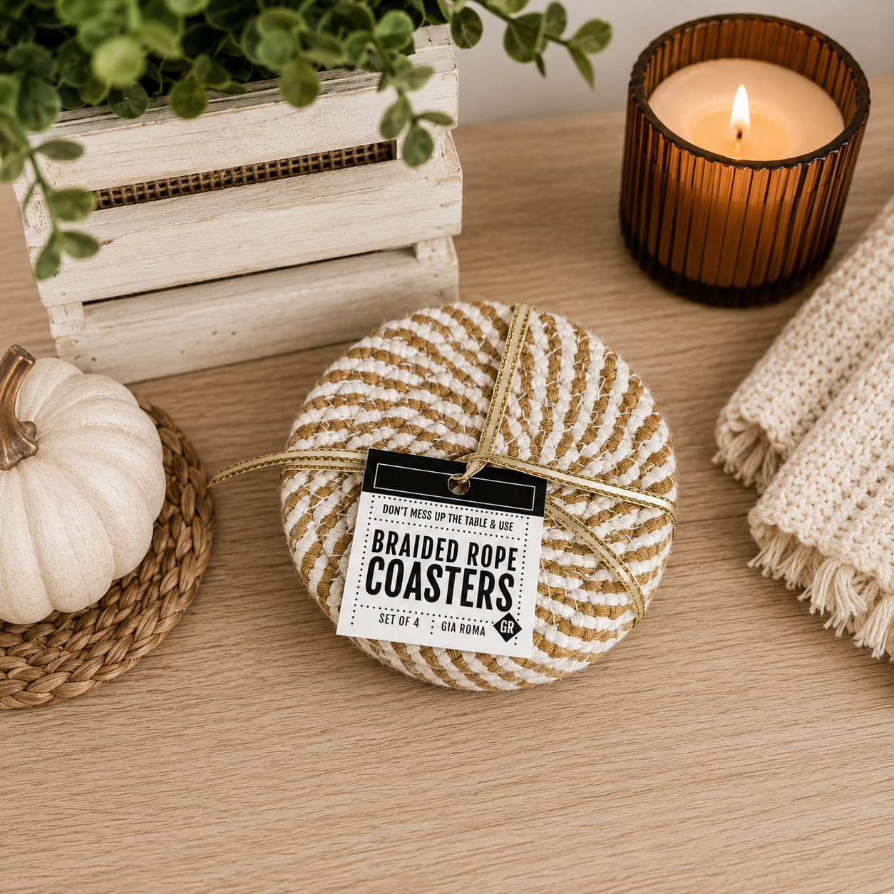 Braided rope coasters with a label on a wooden surface with a candle and pumpkin.