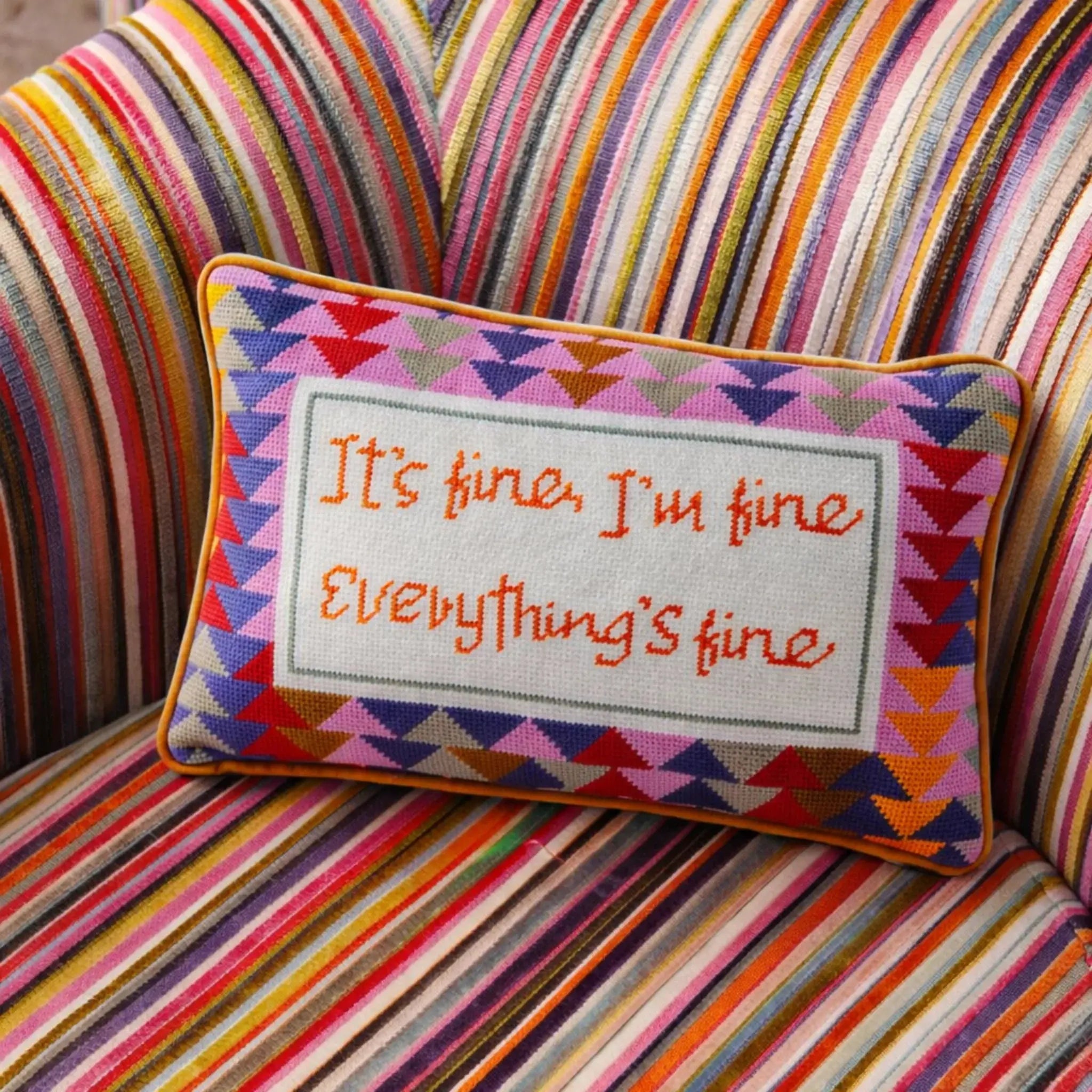 Colorful striped chair with a pillow featuring text on a multicolored background