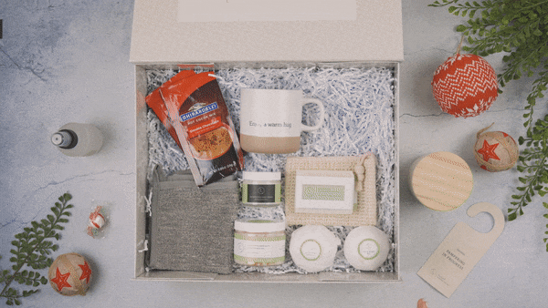 Cozy farmhouse gift box with mug, candles, bath salts, and cozy socks for warm home decor